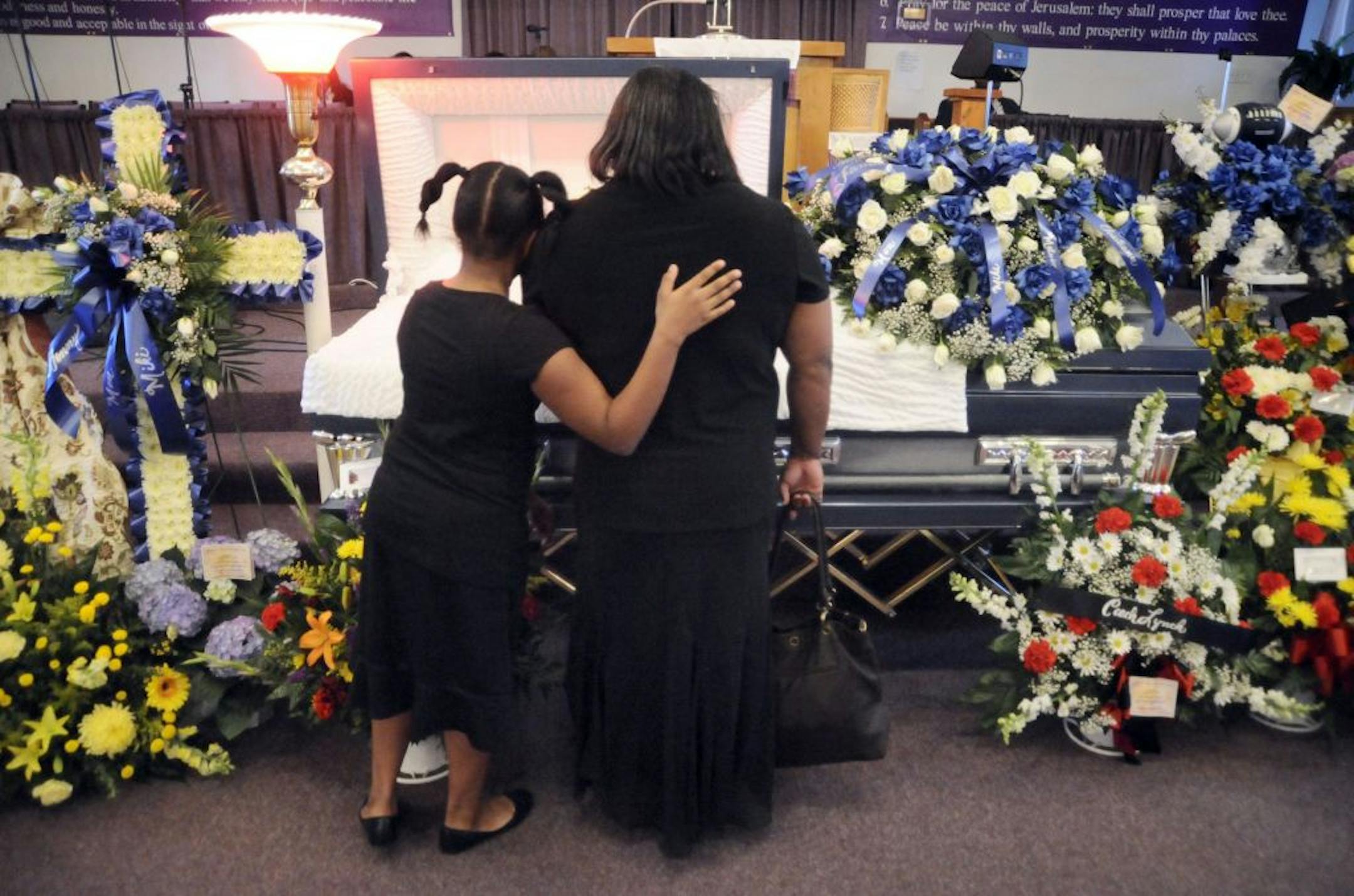 Lynette Hinton, right, is comforted by Jariah Pack while looking at the casket of miner William Roosevelt Lynch of Oak Hill, W.Va.