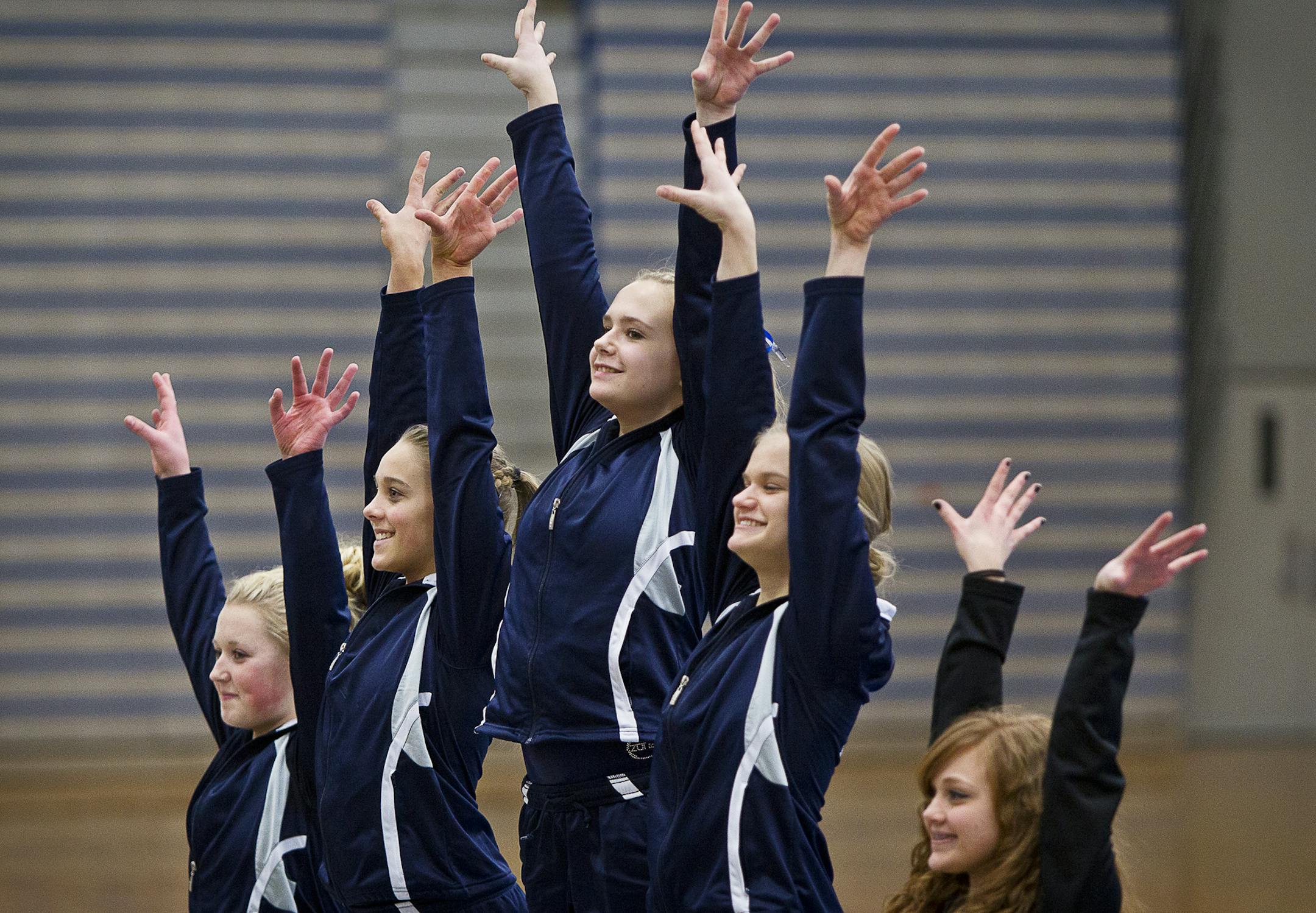 Left to right, Champlin Park's Kayla Uzzell, Taylor Guckeen, Liz Hammond, Amanda Cunningham and Coon Rapids' Kali Lawerence wave from the podium of the vault competition after the dual gymnastics meet between Champlin Park High School and Coon Rapids High School at Champlin Park, Friday, January 31, 2014. Champlin Park won the meet with a combined score of 137.35 over Coon Rapids' 125.975. [ BEN BREWER ‚Ä¢ Special to the Star Tribune _ DATE 1/31/2014 SLUG: PNORTH020514 EXTRA INF