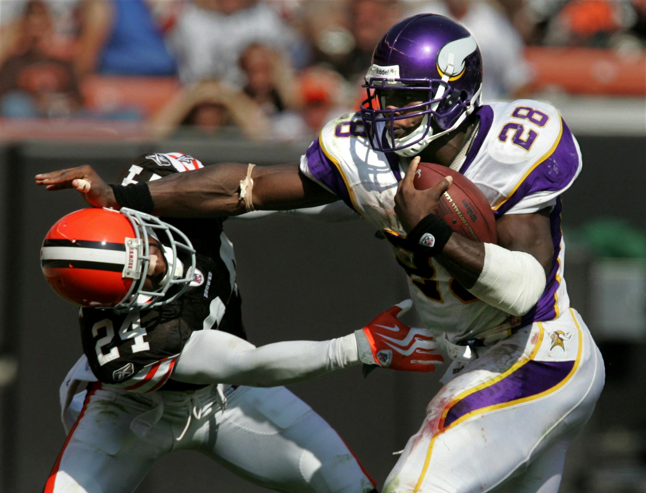 Cleveland Browns defensive back Eric Wright is stiff-armed by Minnesota Vikings Adrian Peterson during Peterson's 64-yard touchdown run in the fourth quarter on Sunday, September 13, 2009, at Cleveland Browns Stadium.