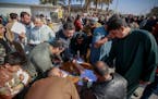 Supporters of the Shiite cleric Muqtada al-Sadr sign a pledge to stand against homosexuality or LGBTQ, outside a mosque in Kufa, Iraq, Friday, Dec. 2,