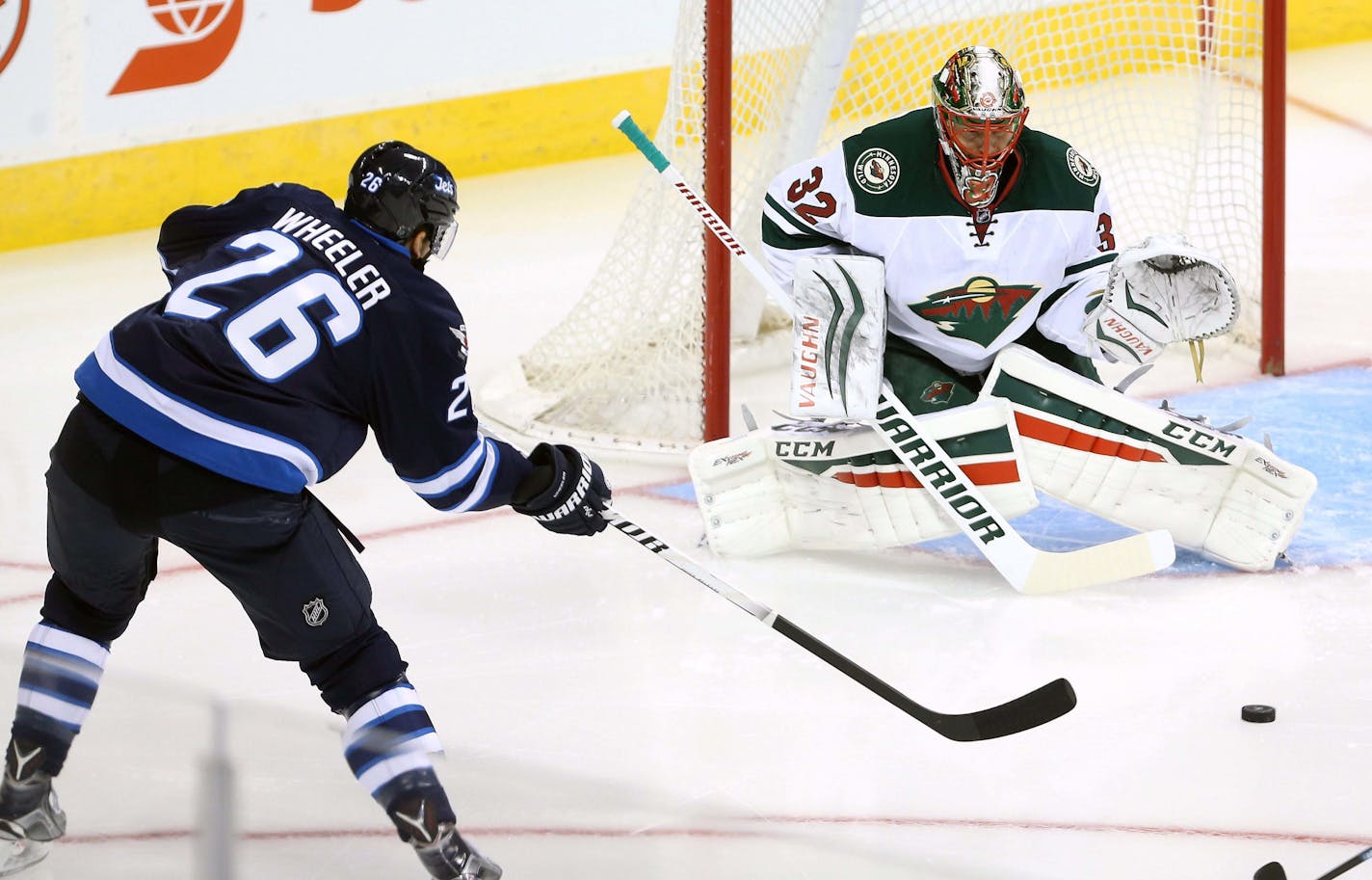 Winnipeg Jets' Blake Wheeler, left, shoots against Minnesota Wild goaltender Niklas Backstrom during the first period of an NHL preseason hockey game Tuesday, Sept. 22, 2015, in Winnipeg, Manitoba. (Trevor Hagan/The Canadian Press via AP) MANDATORY CREDIT