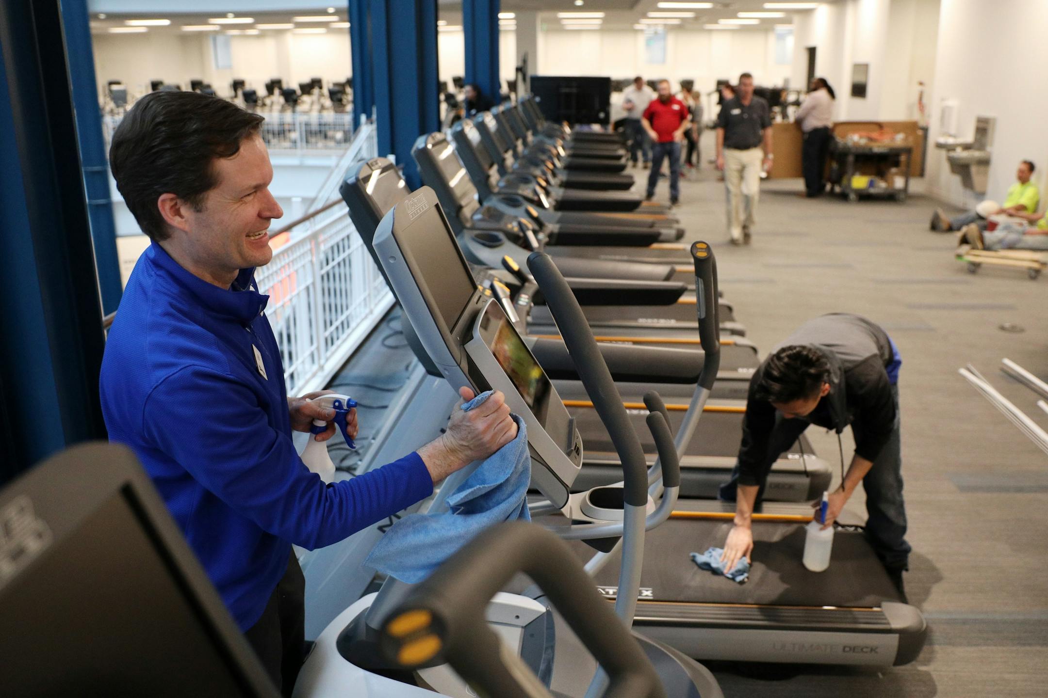 Glen Gunderson, left, president and chief executive officer of the YMCA of the Greater Twin Cities, helped employees clean exercise equipment in preparation for the grand opening.