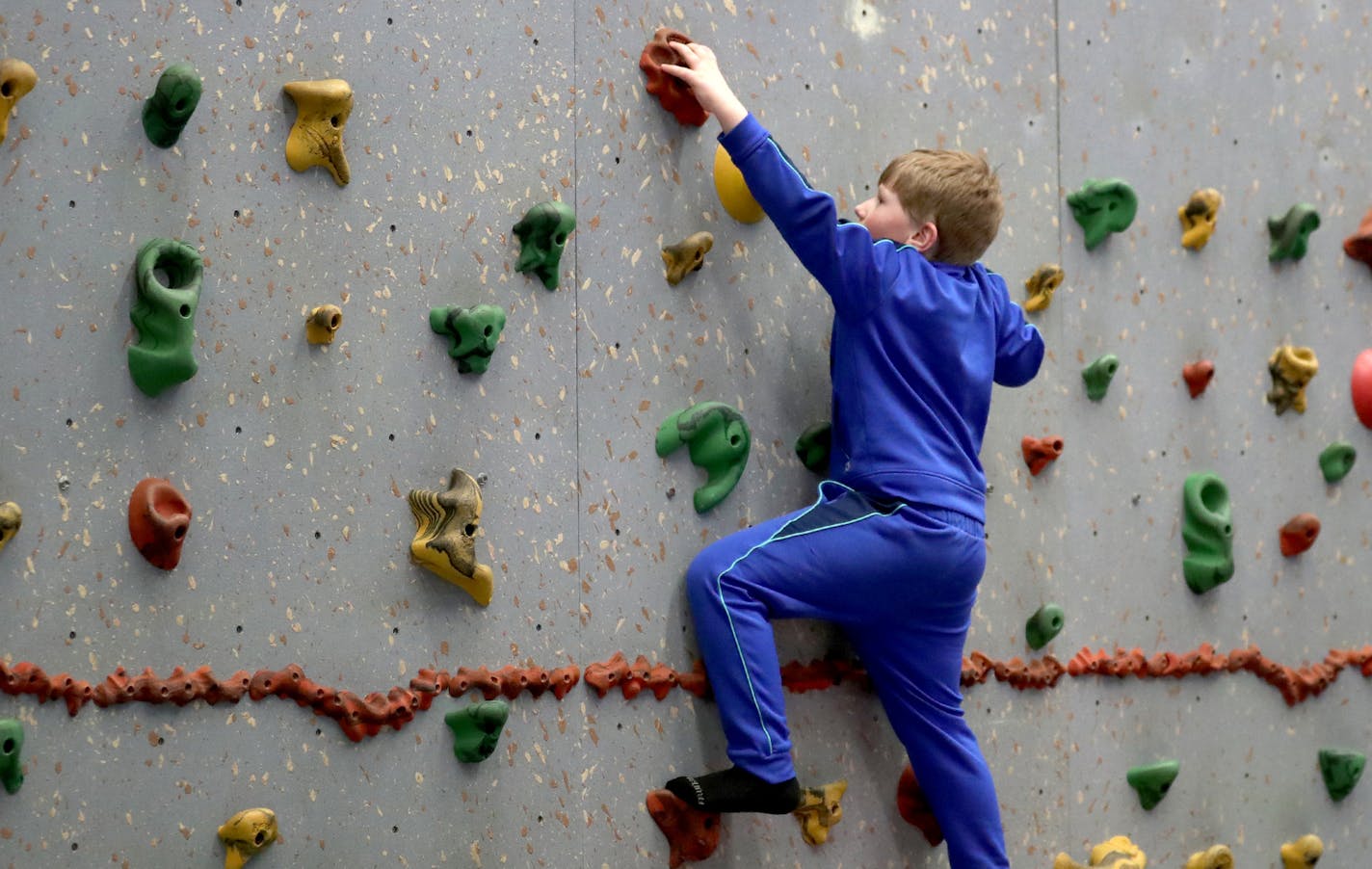 One Friday a month, Autism Friendly Austin sponsors a respite night where parents can drop off their kids and get a break from caregiving. The kids are left with trained facilitators who care for them for the evening. Here, Kayde Gustafson scales a climbing wall at the YMCA Friday, April 20, 2018, in Austin, MN.