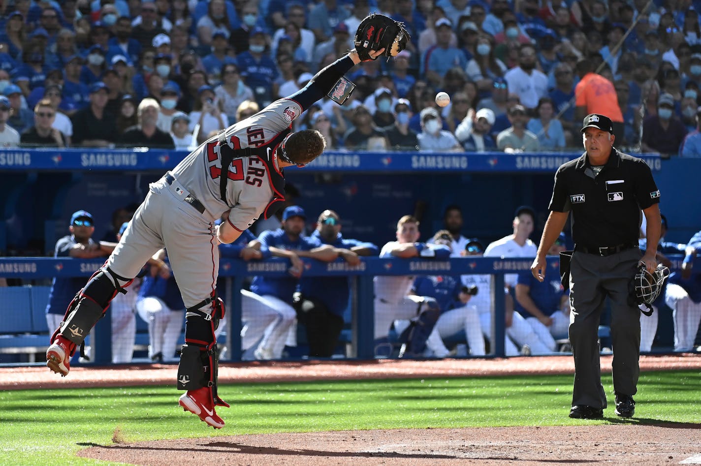 Minnesota Twins catcher Ryan Jeffers misses catching a pop-up fly ball off the bat of Toronto Blue Jays' George Springer in the first inning of a baseball game in Toronto on Saturday, Sept. 18, 2021. (Jon Blacker/The Canadian Press via AP)