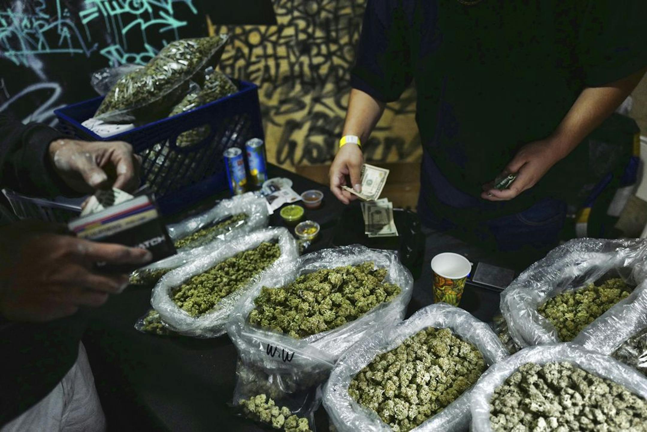 FILE - In this April 15, 2019, file photo, a vendor makes change for a marijuana customer at a cannabis marketplace in Los Angeles. Voters in four states could embrace broad legal marijuana sales on Election Day, setting the stage for a watershed year for the industry that could snowball into neighboring states as well as reshape policy on Capitol Hill. The Nov. 3, 2020, contests will take place in markedly different regions of the country, New Jersey, Arizona, South Dakota and Montana and appro