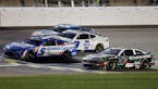 Kyle Larson (5) crosses the finish line milliseconds in front of Chris Buescher (17) for the win during a NASCAR Cup Series auto race at Kansas Speedw