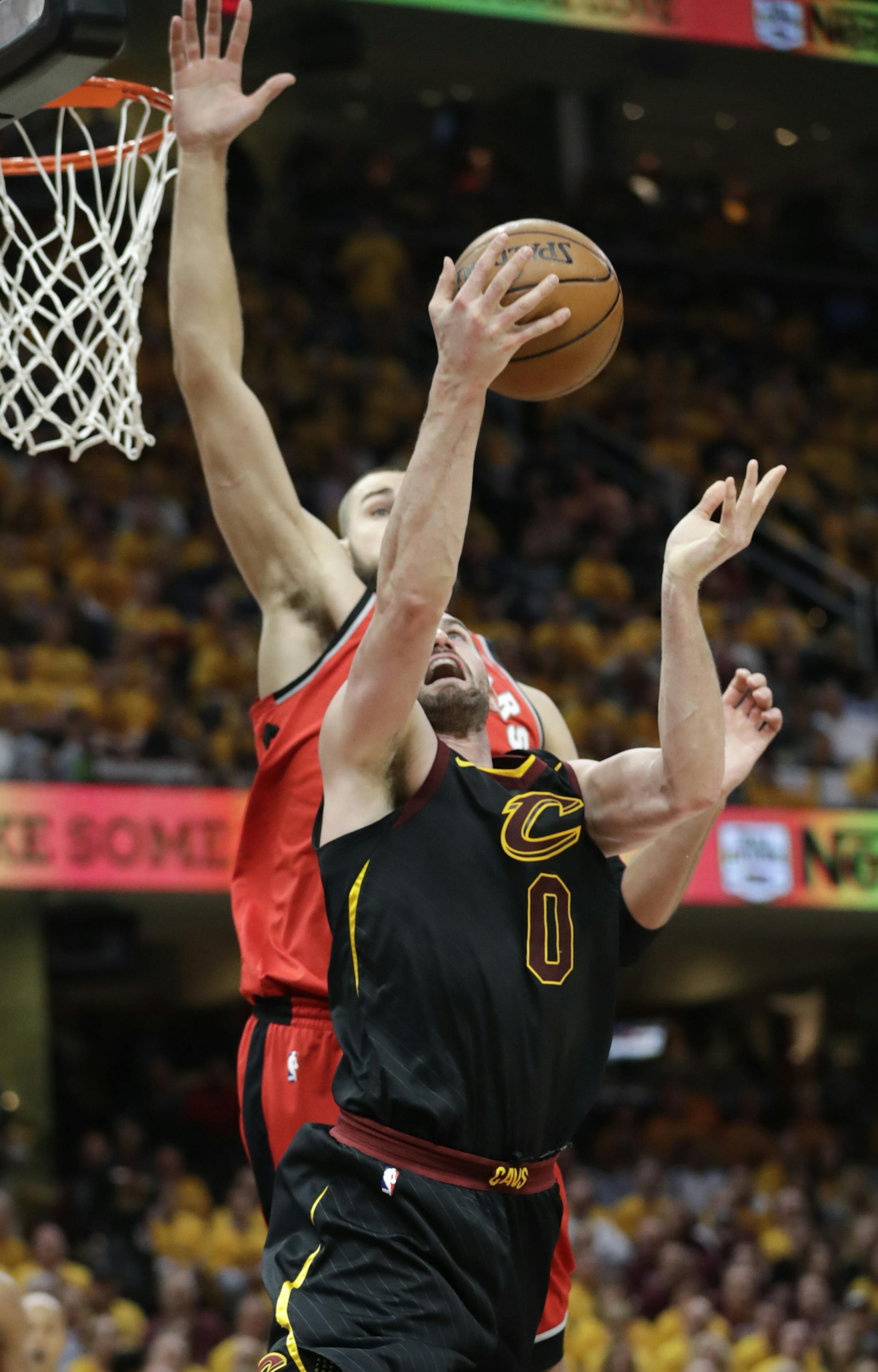 Cleveland Cavaliers' Kevin Love (0) shoots against Toronto Raptors' Jonas Valanciunas in the first half of Game 4 of an NBA basketball second-round playoff series, Monday, May 7, 2018, in Cleveland. (AP Photo/Tony Dejak)