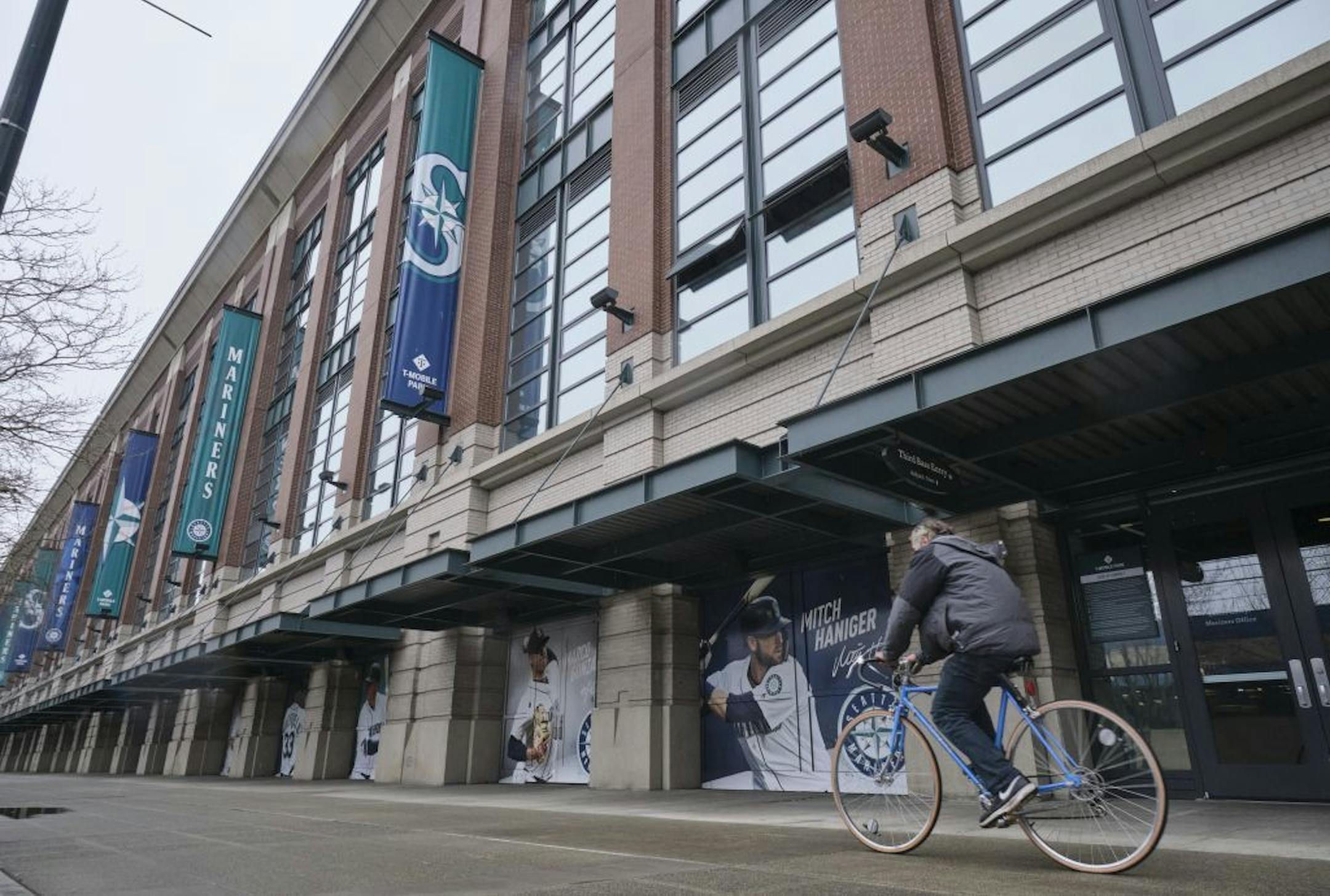 A bicyclist rides past T-Mobile Park, Wednesday, March 11, 2020, in Seattle, where baseball's Seattle Mariners plays home games.