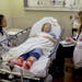 Nurses Lisa Lui-Popelka, left, and&#xa0;Emily Ruben, right, talk with&#xa0;Northwestern Memorial Hospital patient Carol Wittwer at her bedside in a sp