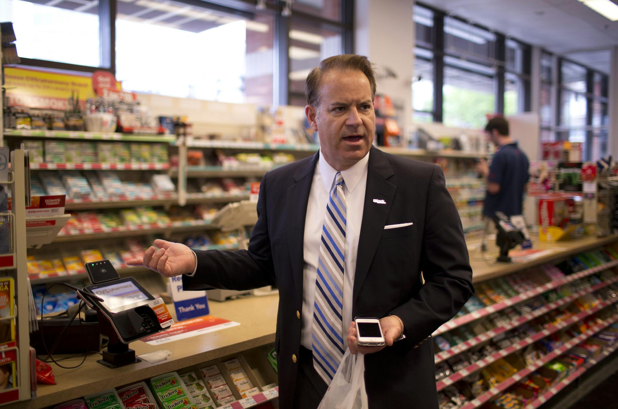 Minneapolis-based U.S. Bank now lets you substitute a wave of the cell phone for a swipe of the credit card at certain retail establishments. Todder Moning, U.S. Bank's senior vice president of payments innovation, talked about NFC technology after paying for candy and a soft drink by waving an iPhone at a wireless reader at the CVS/pharmacy store at 11th St. & Hennepin Ave. in Minneapolis Thursday afternoon, June 6, 2013. The service requires a Near Field Communication (NFC) card in a special (