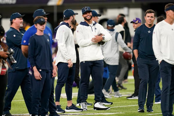 Injured Dallas Cowboys quarterback Dak Prescott, center, stands on the field  before Sunday’s game.