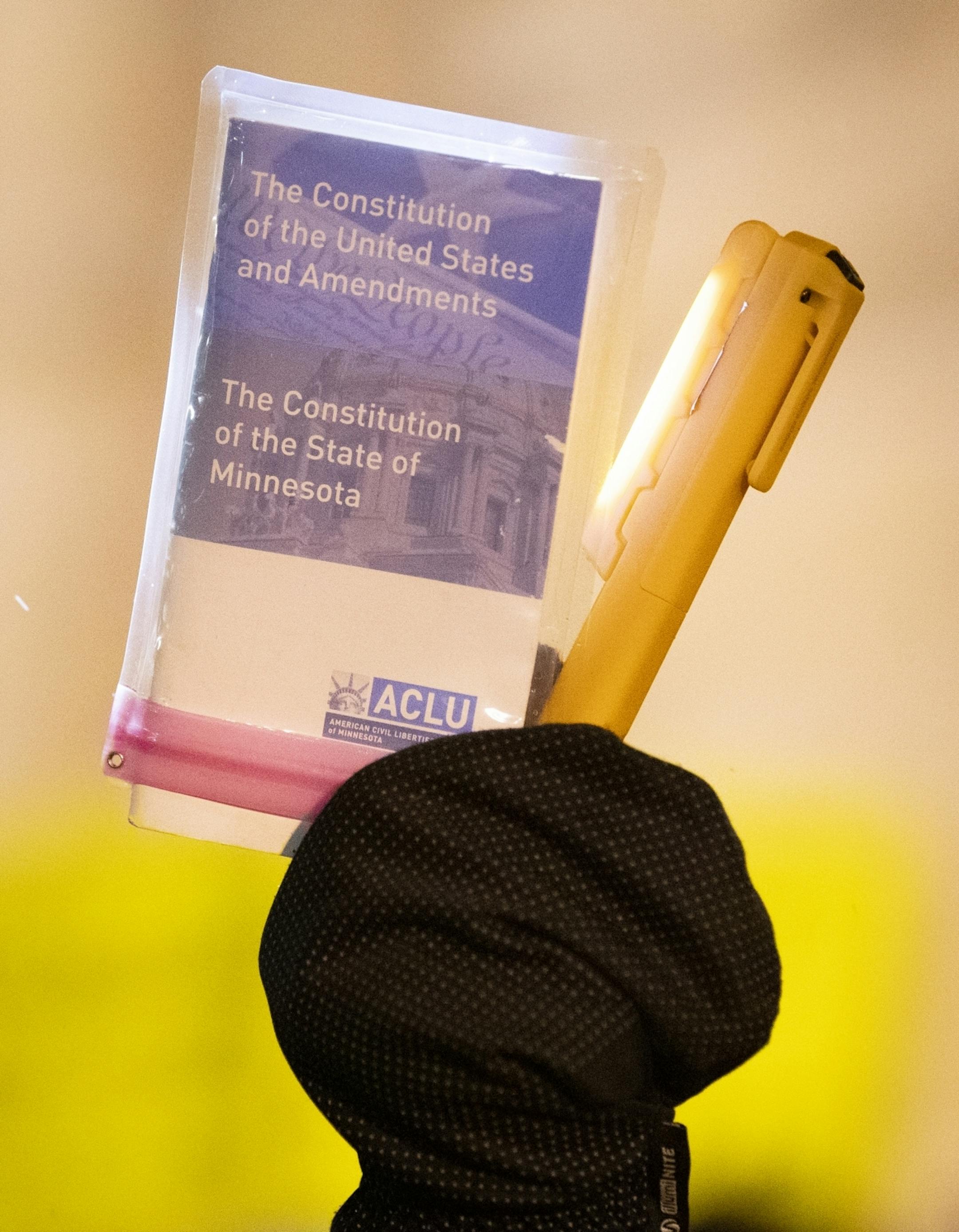 A protester holds a copy of the Constitution with their mittened hand during a protest in support of Special Counsel Robert Mueller's investigation.