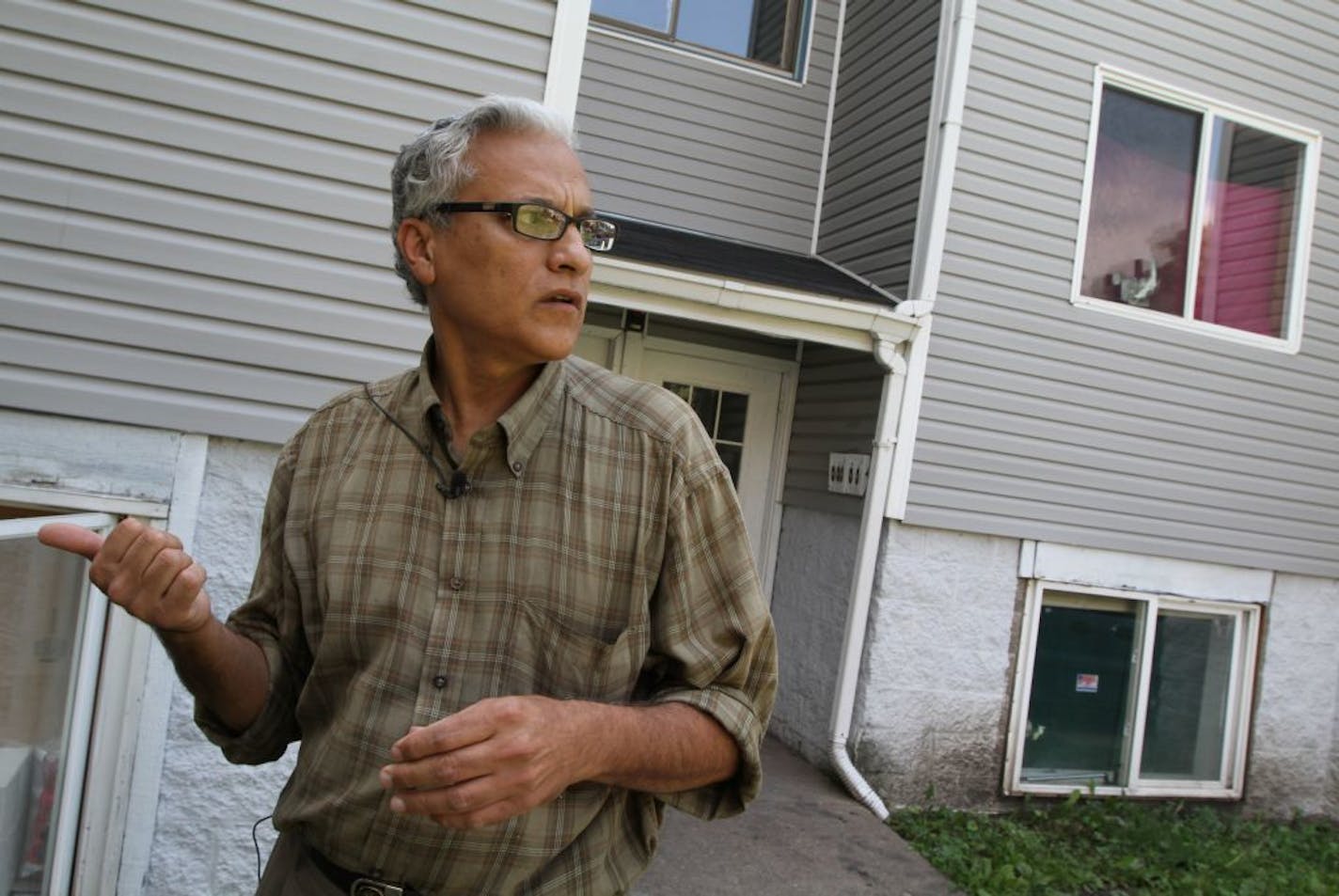 Minneapolis landlord Mahmood Khan in front of one of his rental properties in northeast Minneapolis in 2012.