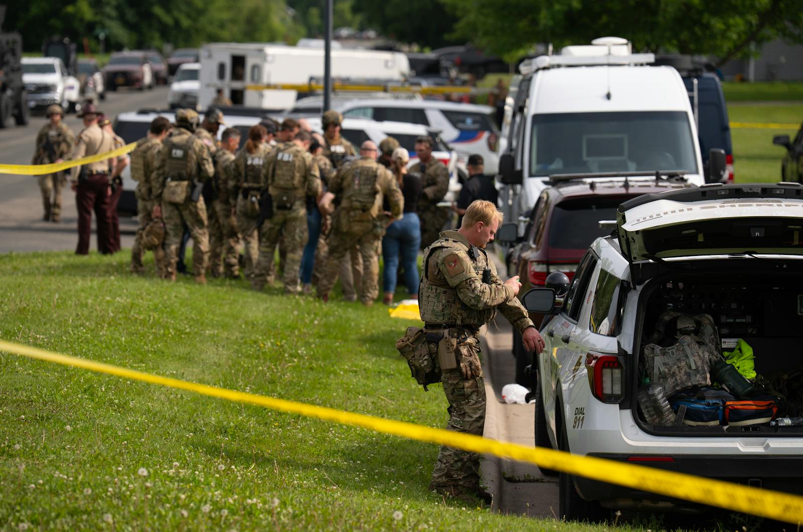Public safety officers stage at Green Isle Irish Baseball Field in Green Isle, Minn., continuing the search for the fugitive Vance Boelter.