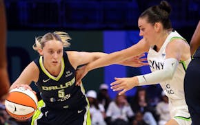 Dallas guard Paige Bueckers, a Minnesotan in her first WNBA game, drives the ball past Lynx forward Bridget Carleton on Friday in Arlington, Texas.