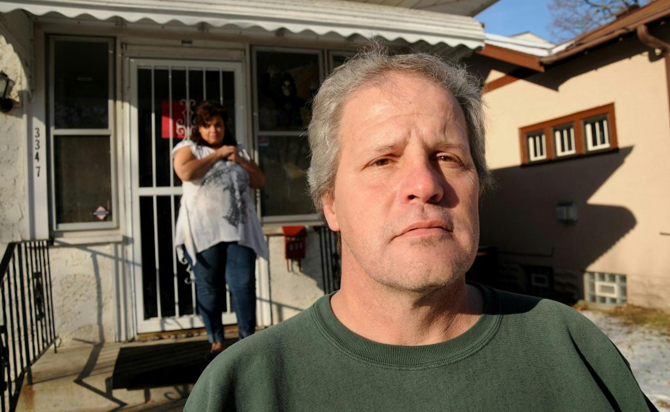 Ronald Folger stood in front of one of the 17 homes he owns on the north side of Minneapolis. Losing the rental licenses means that tenant Tira Jones, background, and others would need to find new places to live.