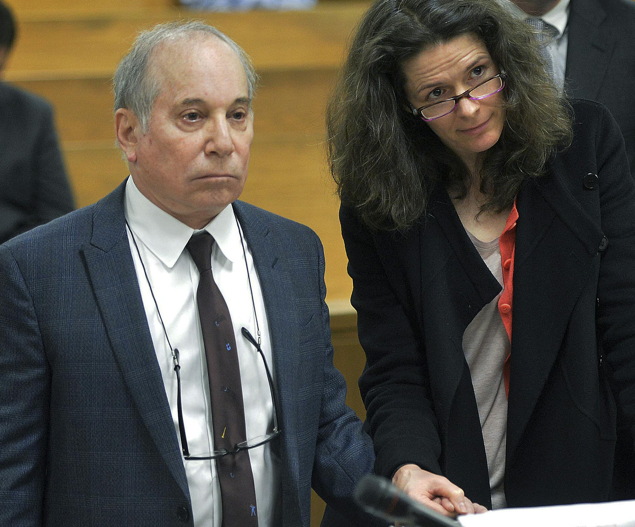 Singer Paul Simon, left, holds hands with his wife Edie Brickell at a hearing in Norwalk Superior Court on Monday April 28, 2014 in Norwalk, Conn. The couple were arrested Saturday on disorderly conduct charges by officers investigating a family dispute at their home in New Canaan, Conn. (AP Photo/The Hour, Alex von Kleydorff, Pool)