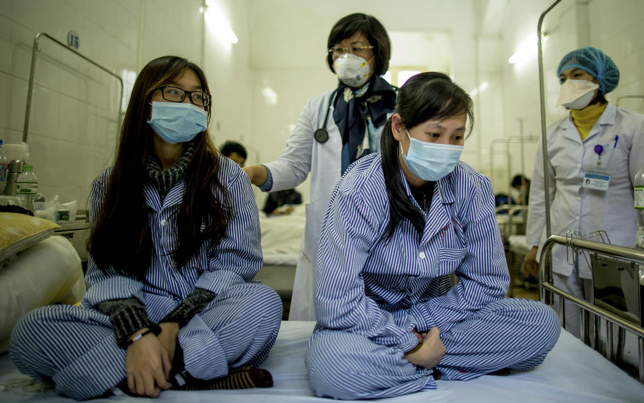 Dr. Hoang Thi Phuong, head of the Respiratory Tuberculosis Department at the National Lung Hospital in Hanoi, Vietnam examines two patients with tuberculosis, Jan. 26, 2016. The country’s stunning progress against deadly tuberculosis is being threatened by reduced funding for a health care system stretched thin. (Justin Mott/The New York Times)