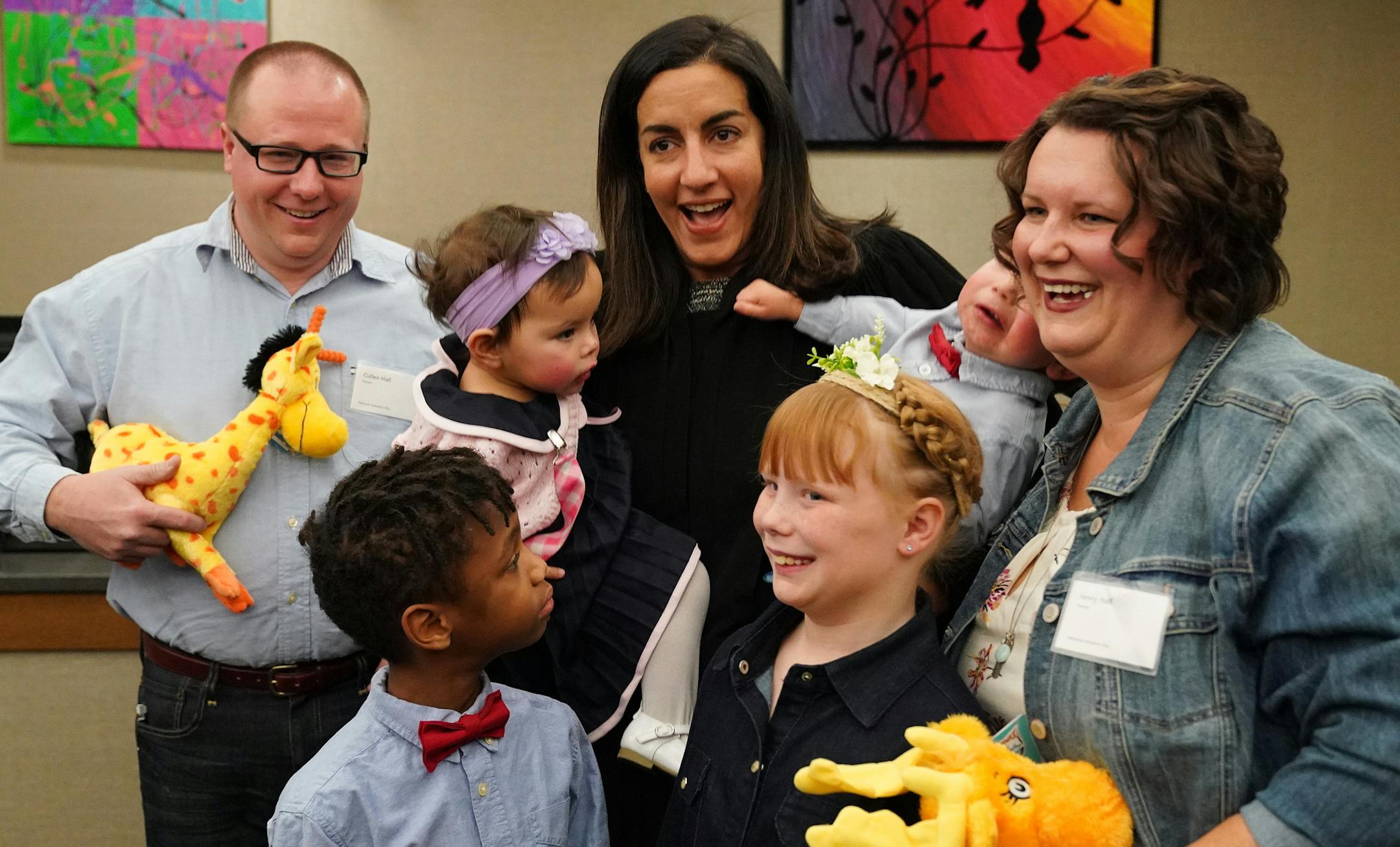 Judge Shereen Askalani smiled as she held 15-month-old Charlotte and her twin brother Titus after they were adopted by Jenny, right, and Cullen Hall, left, while they posed for photos in the courtroom with their other two children Nehemiah, 7, and Eleanor, 8, after finalizing the adoption process during National Adoption Day at the Juvenile Justice Center. ] ANTHONY SOUFFLE • anthony.souffle@startribune.com On National Adoption Day, 14 families adopted 22 children Saturday, Nov. 23, 2019