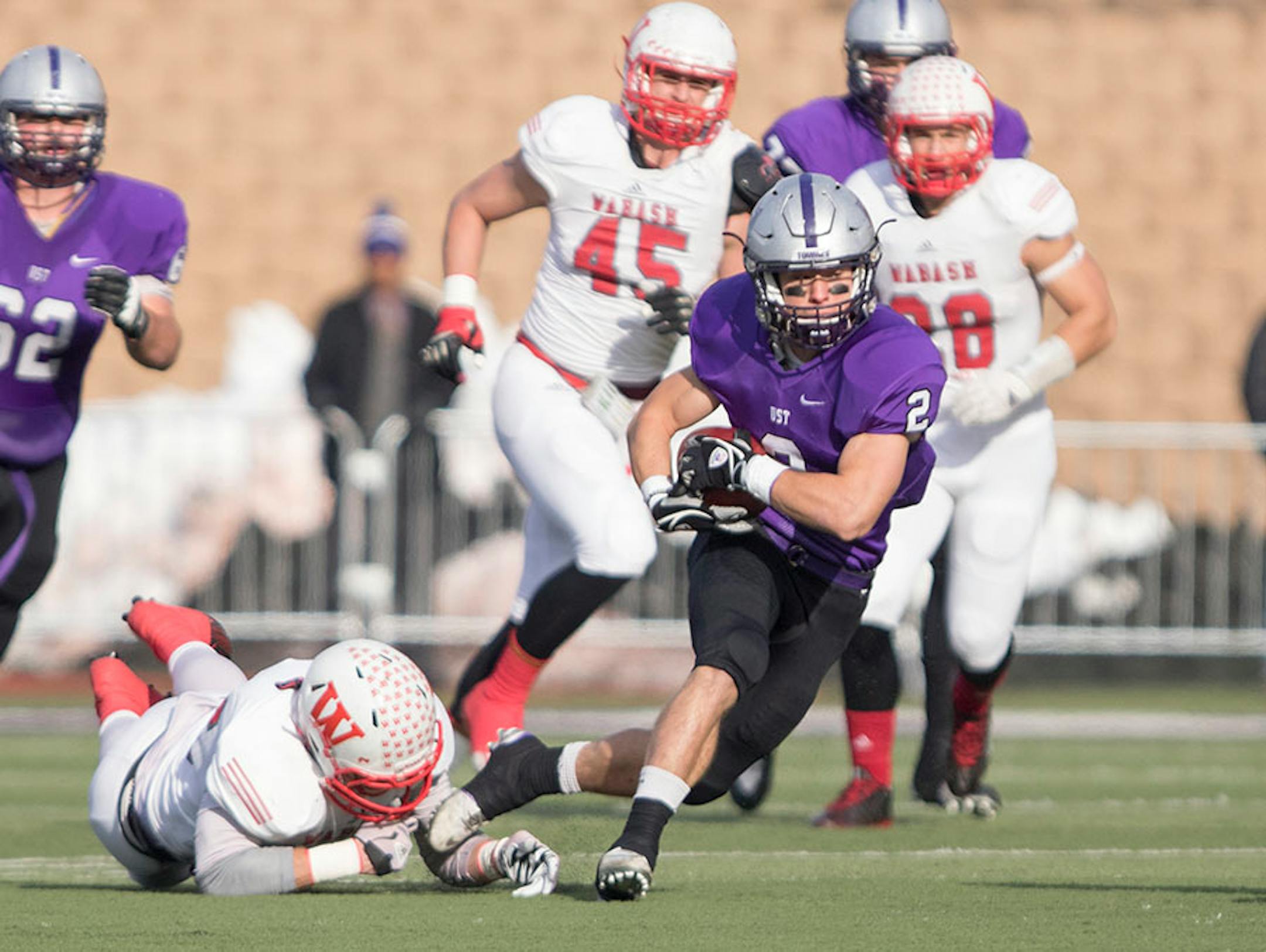 St. Thomas receiver Nick Waldvogel (2) breaks a tackle, Wabash DB Eddie Cmehil (13) is waiting to make the stop as the University of St. Thomas Tommies hosted the Wabash College Little Giants on December 5, 2015.