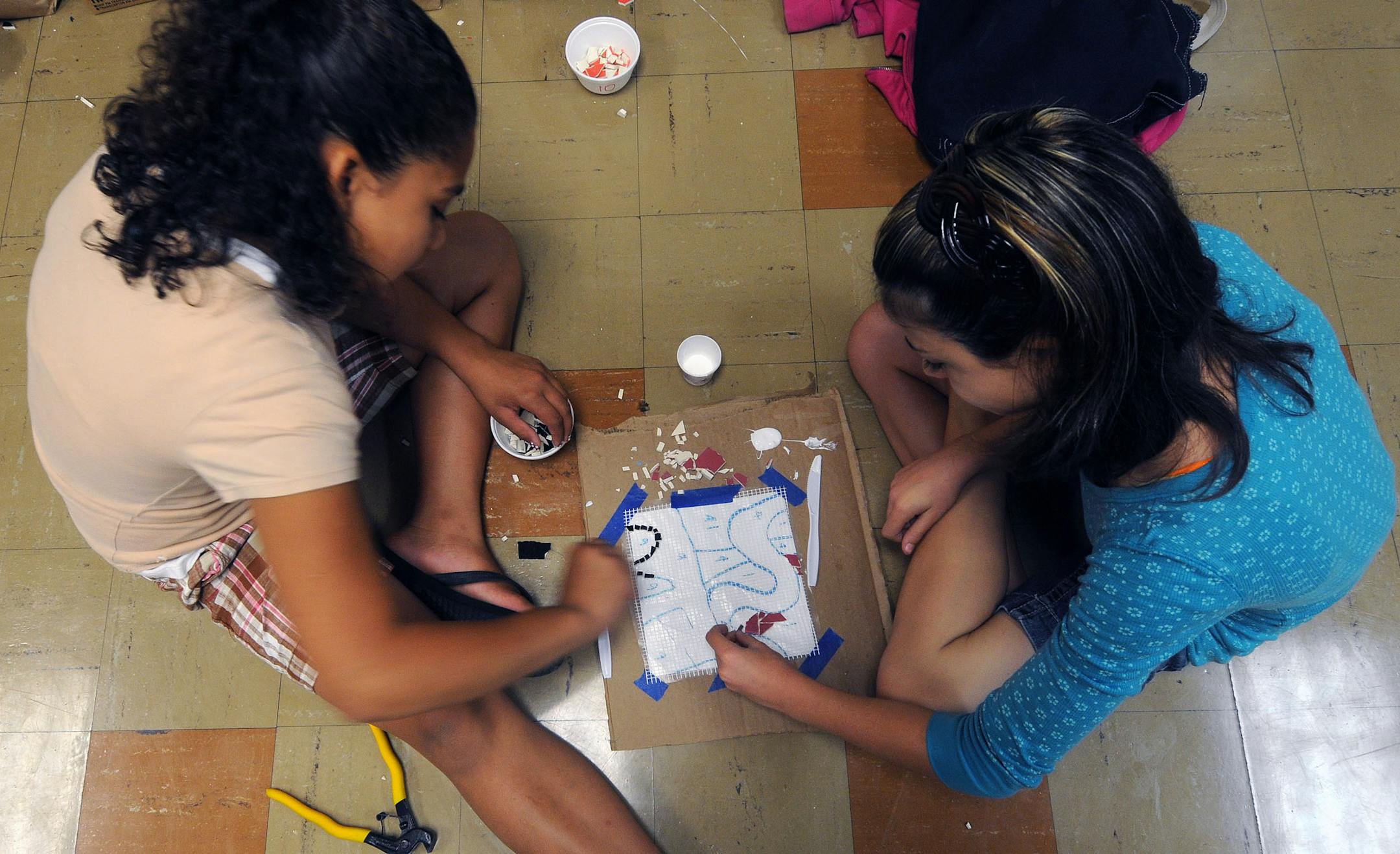 Sandburg summer-school students Jennifer Hunt and Miranda Van Ravenstein worked on applying ceramic tile to a square panel.