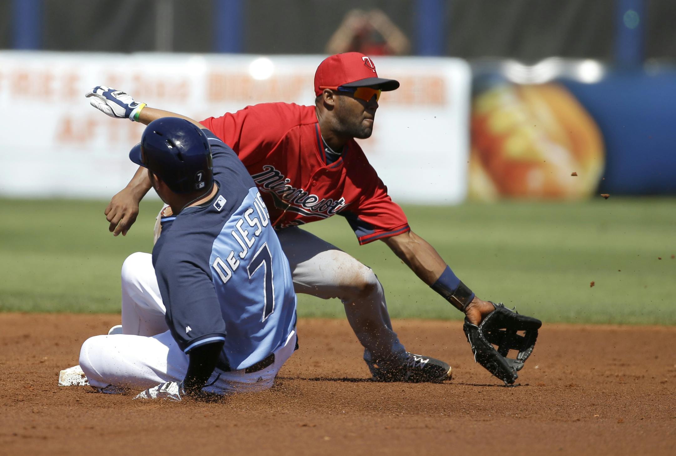 Tampa Bay Rays' David DeJesus, left, reaches second on a double off Minnesota Twins' Ricky Nolasco as Twins shortstop Danny Santana, right, waits for the ball in the first inning of an exhibition baseball game, Sunday, March 2, 2014, in Port Charlotte, Fla. (AP Photo/Steven Senne)
