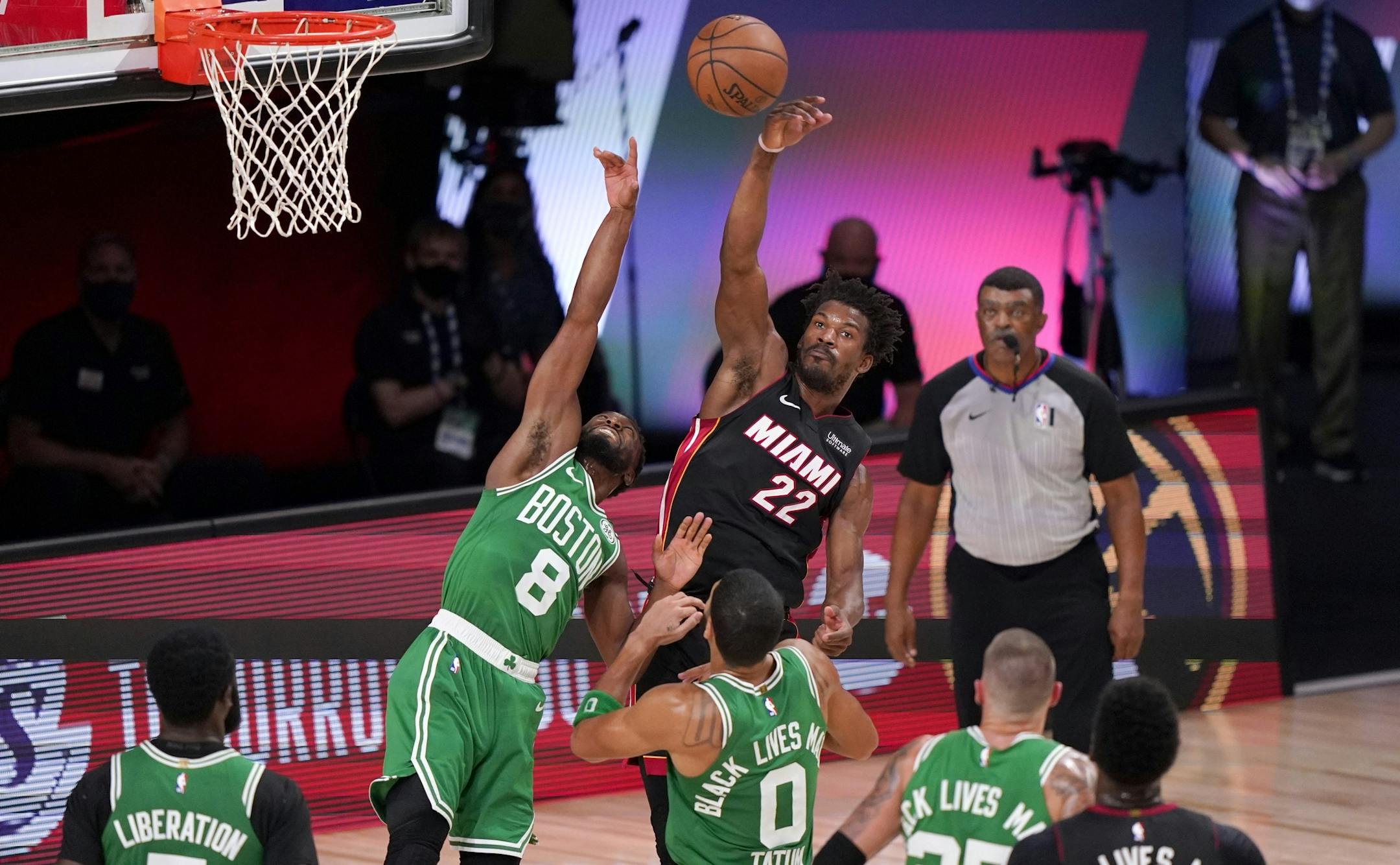Miami Heat forward Jimmy Butler (22) slaps the ball back after competing against Boston Celtics' Kemba Walker (8) for a rebound during the second half of Game 4 of an NBA basketball Eastern Conference final, Wednesday, Sept. 23, 2020, in Lake Buena Vista, Fla. (AP Photo/Mark J. Terrill)