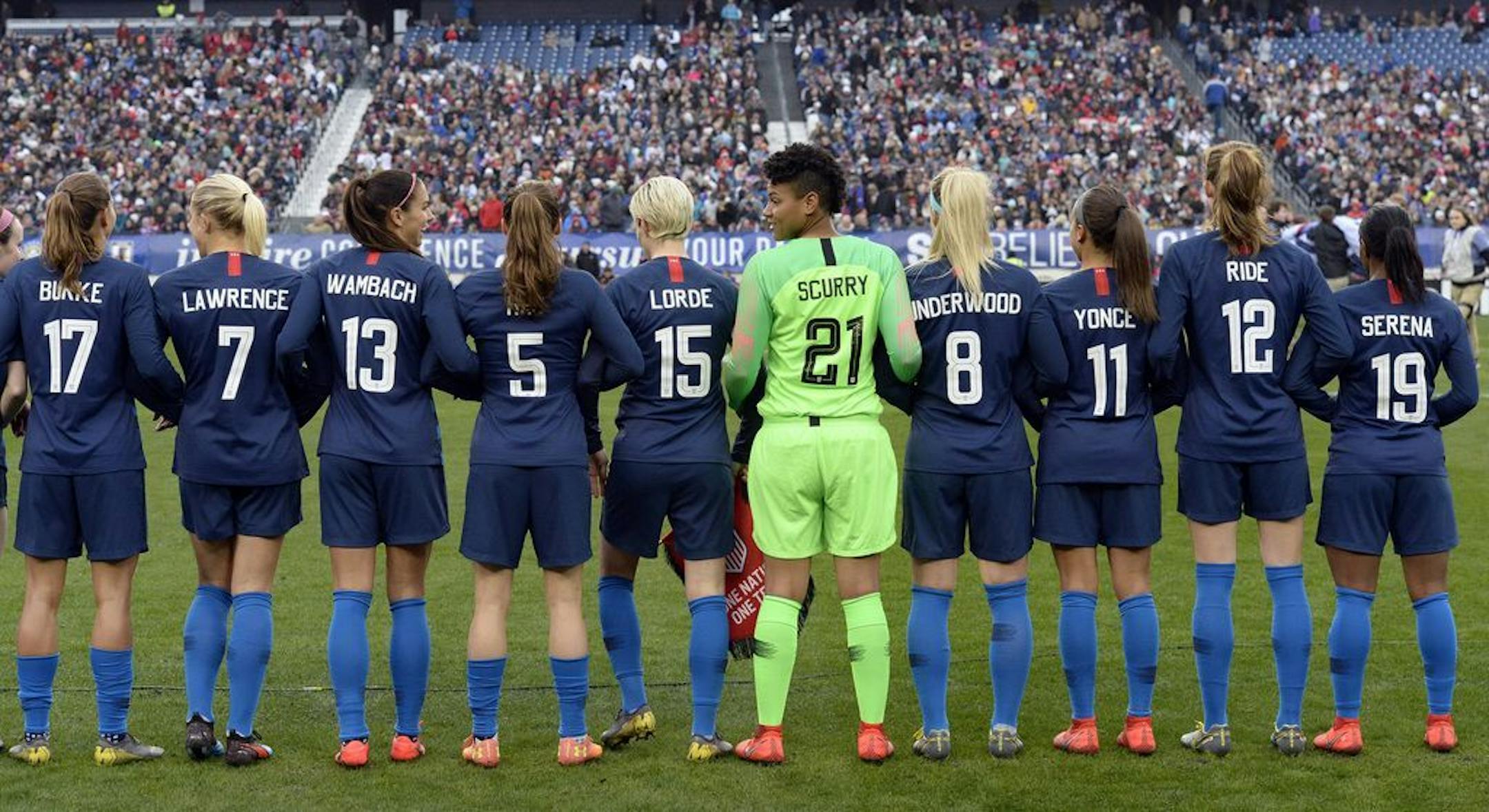 The United States women's national team stand arm-in-arm on the pitch wearing the names of women that inspire them on the back of their jerseys before playing England in a SheBelieves Cup women's soccer match Saturday, March 2, 2019, in Nashville, Tenn.