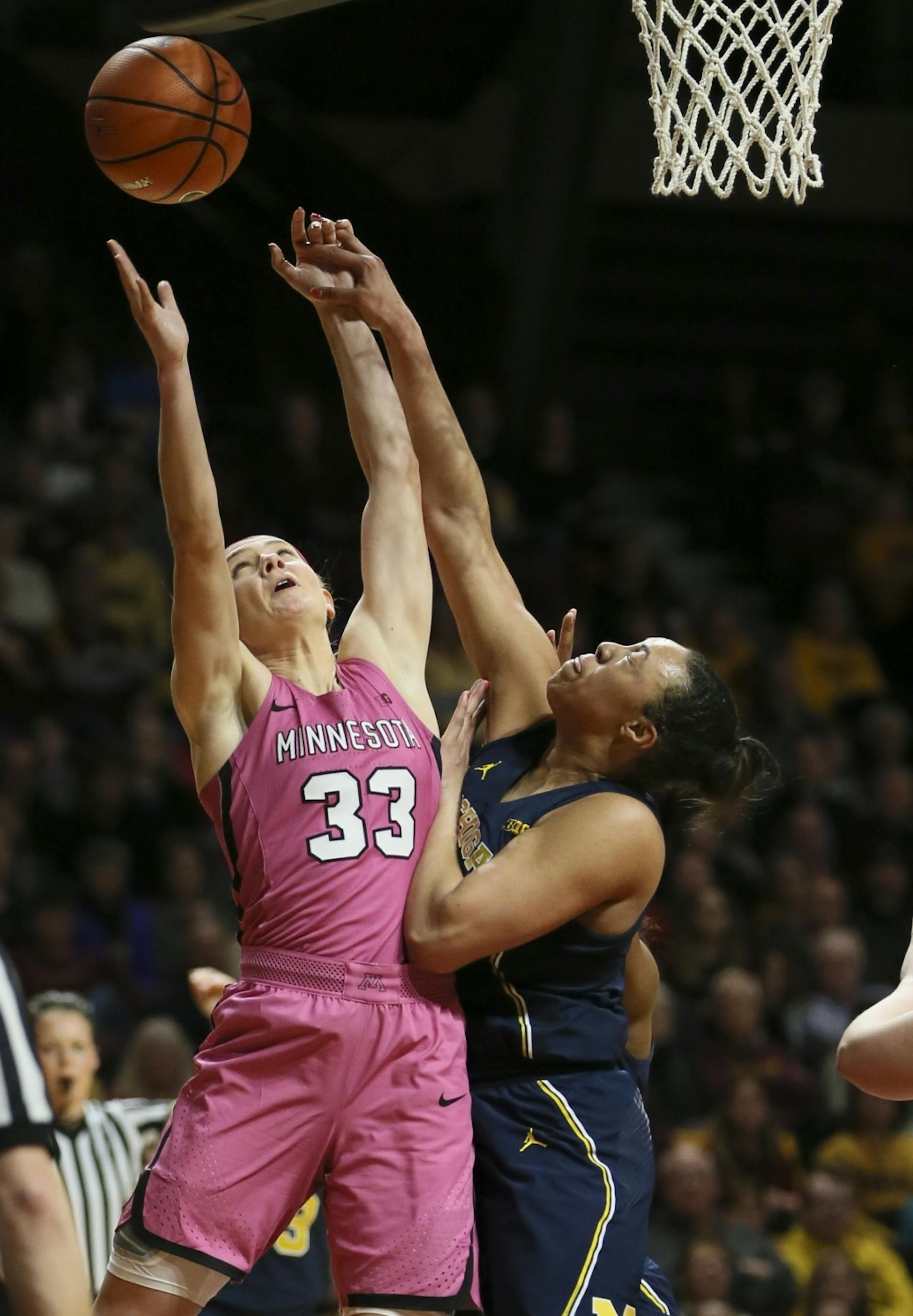 Minnesota Golden Gophers guard Carlie Wagner (33) leapt for a rebound against Michigan Wolverines Jillian Dunston (11) in the first half.