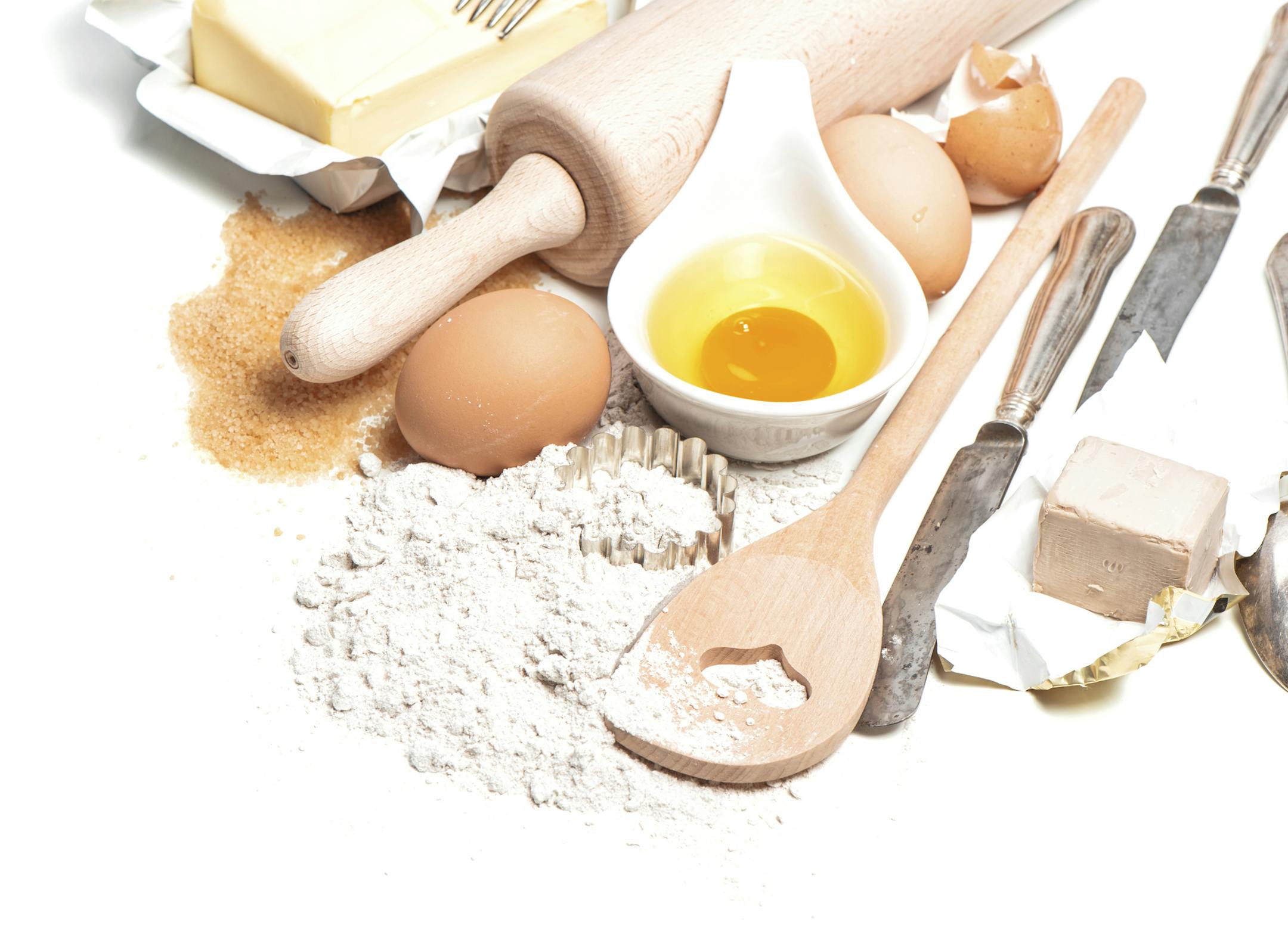 Baking ingredients eggs, flour, sugar, butter, yeast. Food background with antique cutlery, istock photo