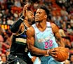 The Miami Heat's Jimmy Butler (22) drives against the Milwaukee Bucks' Wesley Matthews (9) at the AmericanAirlines Arena in Miami on March 2, 2020. (C
