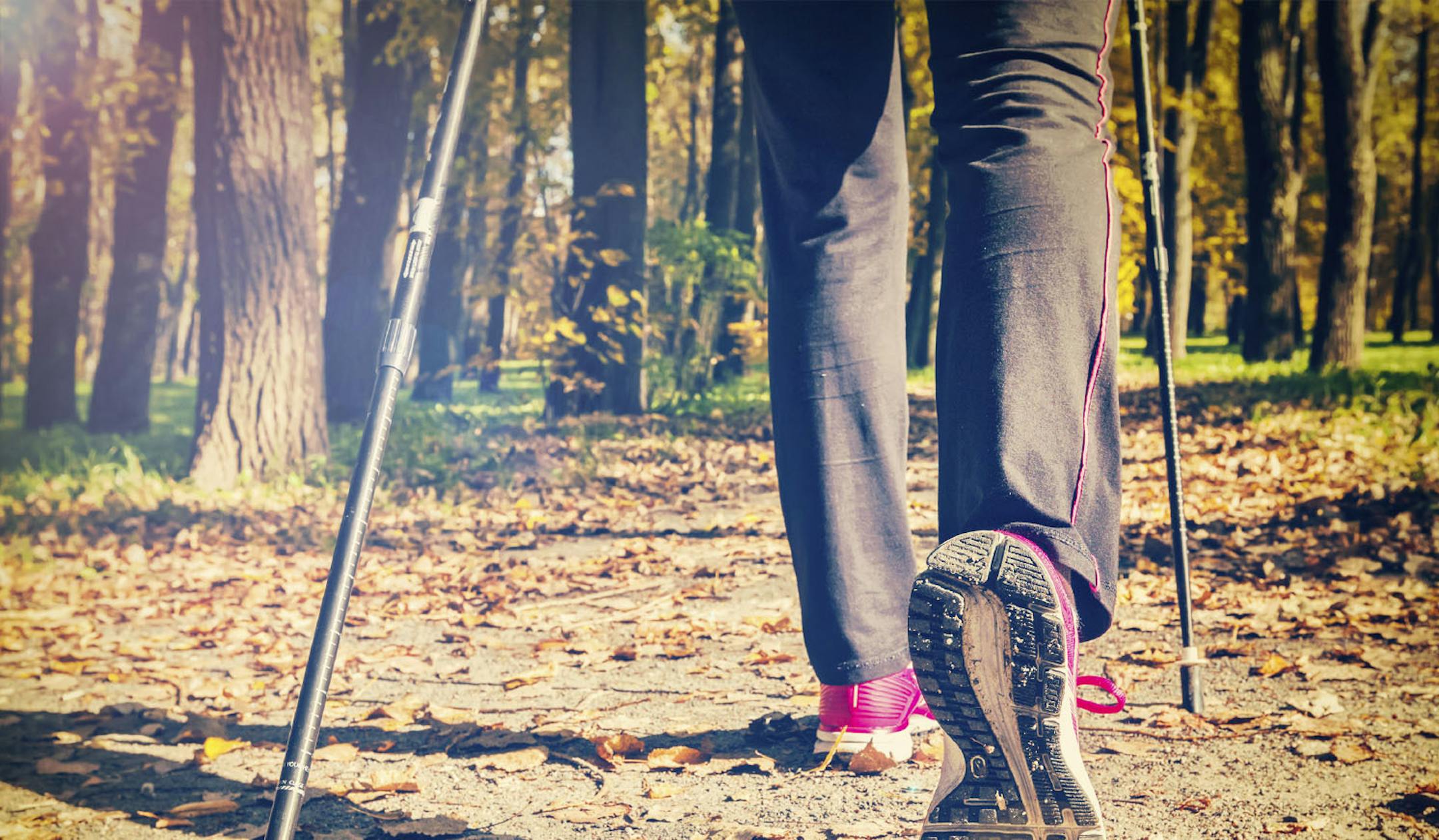 Close up of hinking woman feet and nordic walking poles. Vintage retro effect filtered hipster style image