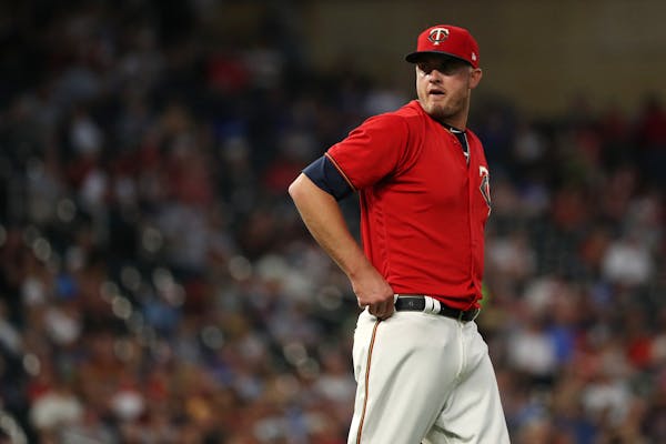 Minnesota Twins relief pitcher Addison Reed (43) looked back as the Minnesota Twins challenged a call in which third baseman Taylor Motter (45) fielde