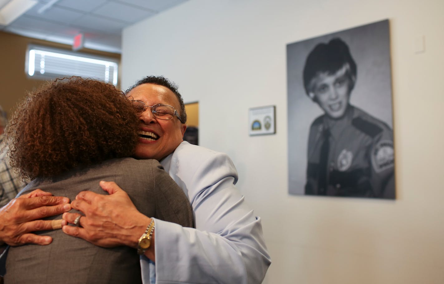 Debbie Montgomery had a warm embrace for Mikeya Griffin, who first met Montgomery when she was a high school student and has been mentored by her ever since. "I'm very proud of her," said Griffin. Over Montgomery's shoulder is a portrait of her as a young officer, as well as the plaque that was unveiled Tuesday afternoon. ] JEFF WHEELER • jeff.wheeler@startribune.com Debbie Montgomery was the first woman police officer as well as the first African American woman police officer in the St. Paul Police Department when she was hired in 1975. Now retired, on Tuesday afternoon, May 3, 2016 a plaque honoring her was dedicated at the St. Paul Police Department's Western District headquarters.