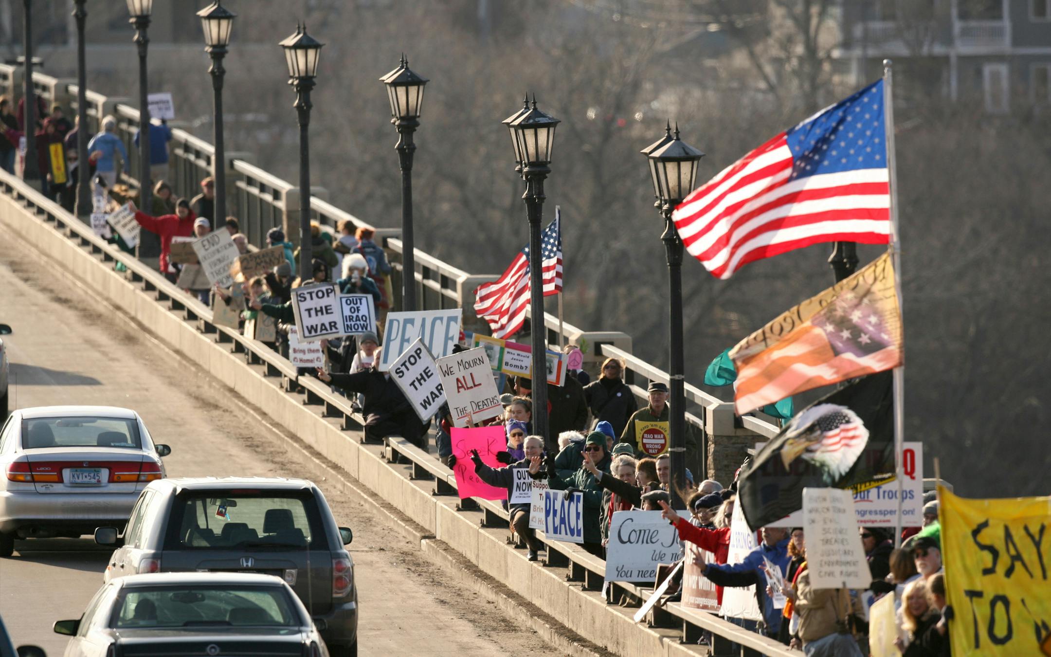 JEFF WHEELER • jwheeler@startribune.com MINNEAPOLIS - 3/19/08 - On the fifth anniversary of the war in Iraq, at least 800 people took part in the weekly demonstration against the war on the Lake Street Bridge, Wednesday evening. A handful of people supporting the war were far outnumbered by those opposed. The weekly participation lately has been only a few dozen people, according to one demonstrator. IN THIS PHOTO: ] Demonstrators, overwhelmingly against the war in Iraq, held signs as car