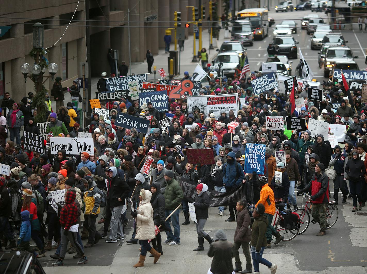 Call for Justice: Jayanthi Kyle, top, chanted with protesters as they stopped in front of the place where Jamar Clark was shot. Protesters marched through downtown Minneapolis on their way to the Hennepin County Government Center and asked for the release of the tapes and prosecution of the police involved.