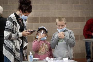 Tammi Bertram and her children Kristalyn, 6, center, and Bentley, 9, took a COVID-19 test at the new saliva testing center in Inver Grove Heights, on 