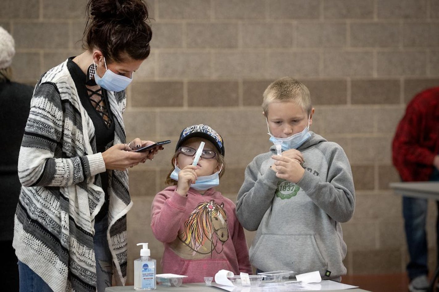 Tammi Bertram and her children Kristalyn, 6, center, and Bentley, 9, took a COVID-19 test at the new saliva testing center in Inver Grove Heights, on Wednesday, Nov. 18.