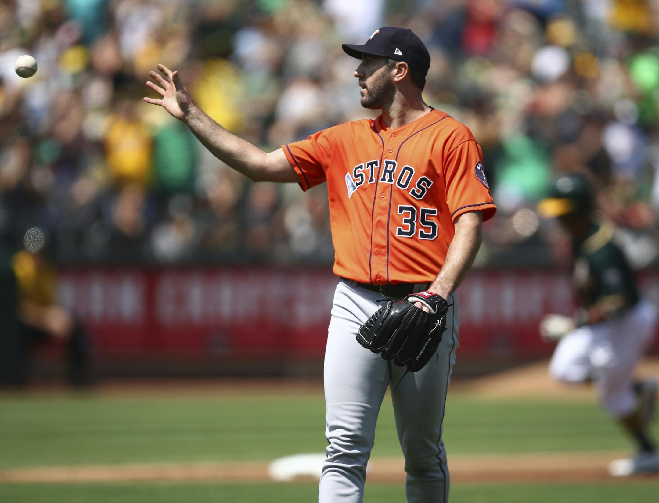 Houston Astros pitcher Justin Verlander gets a new ball after giving up a two-run home run to Oakland Athletics' Khris Davis, right, in the third inning of a baseball game Sunday, Aug. 19, 2018, in Oakland, Calif. (AP Photo/Ben Margot)