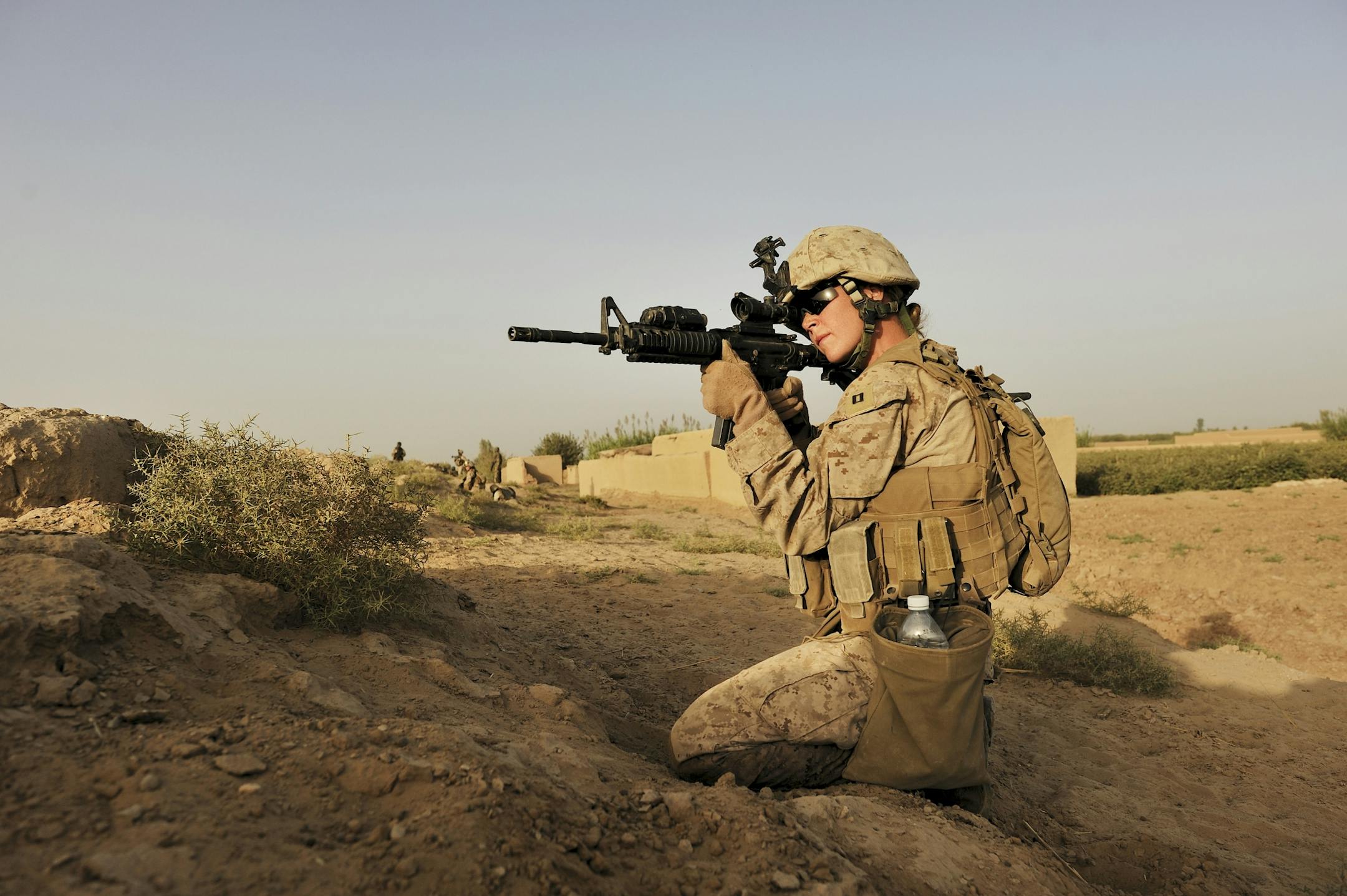 U.S. Marine Capt. Emily Naslund, who is part of a group of female Marines tasked with interacting with Afghan women, aims her weapon after shots were fired at her patrol in Southern Marja, Afghanistan, Sept. 15, 2010.