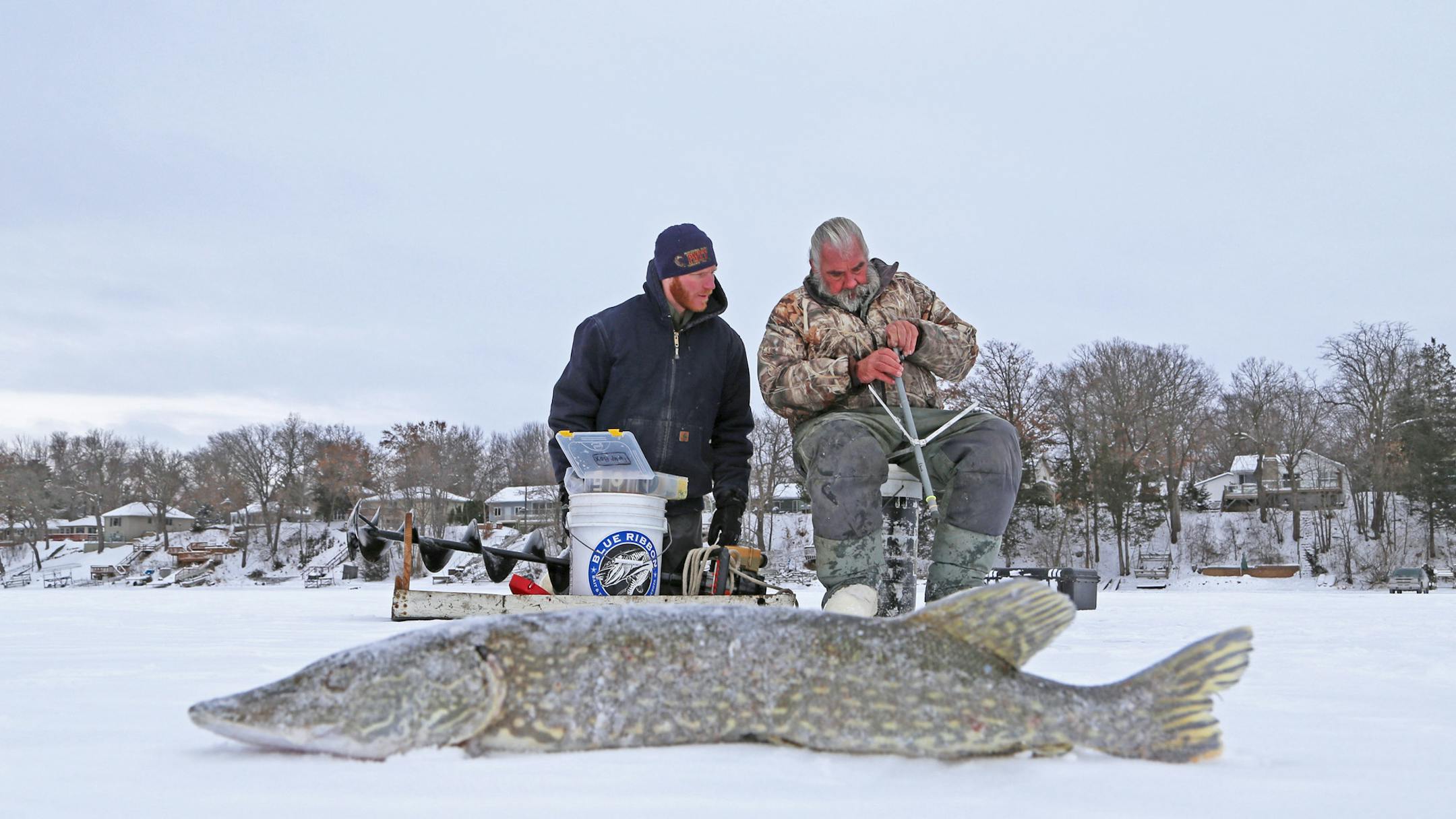 Frank Weeda, left, of Shoreview and Dick “Griz’’ Grzywinski of St. Paul re-rigged a tip-up on a Chisago Lakes area lake Friday morning. Winter anglers are allowed two lines.