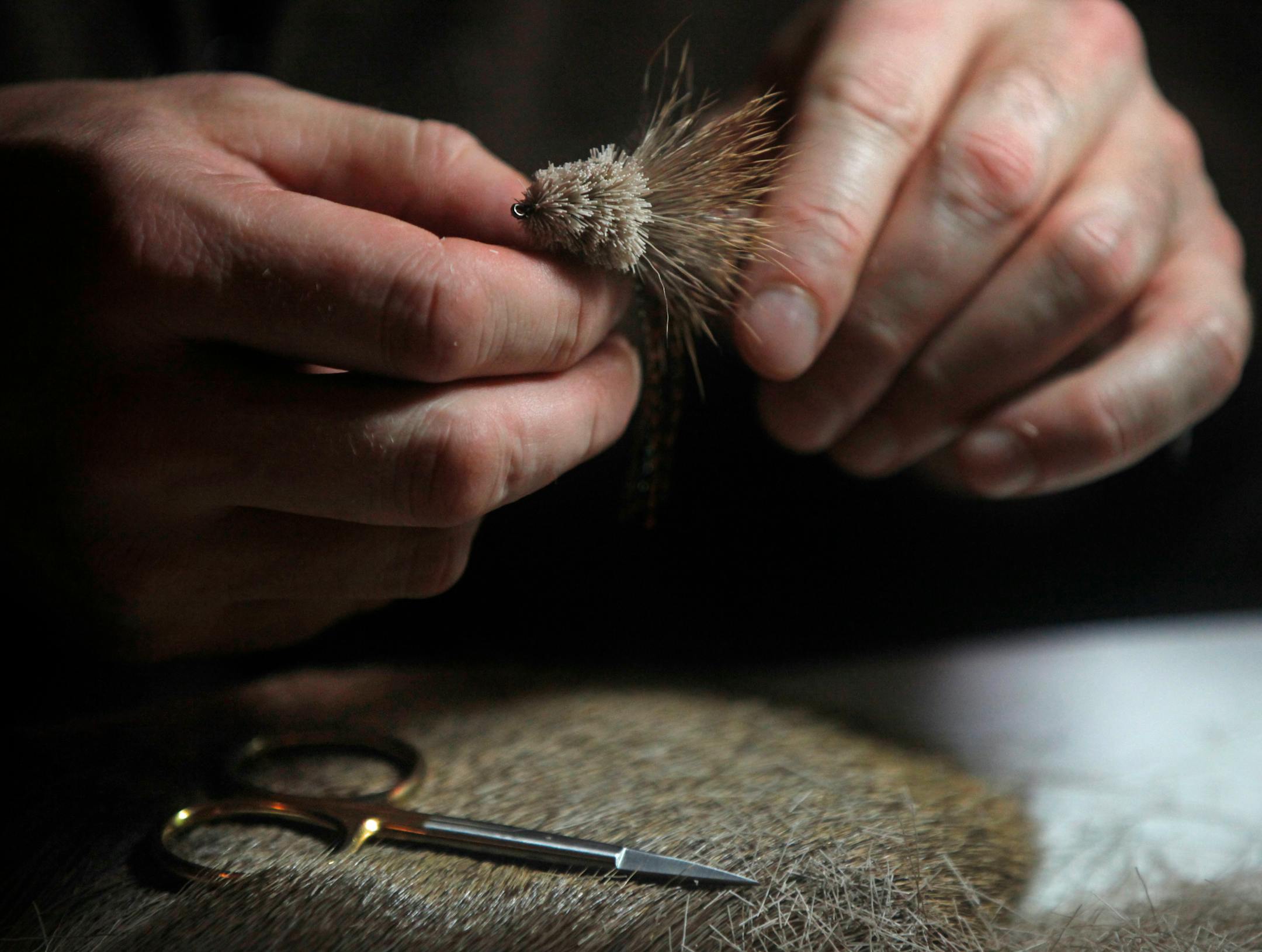 At Schroeder's Bar & Grill in St. Paul, Tony Stifter, who has been flyfishing since he was 12, ties a bass fly that includes the use of chicken feathers and deer hair.]richard tsong-taatarii/rtsong-taatarii@startribune.com