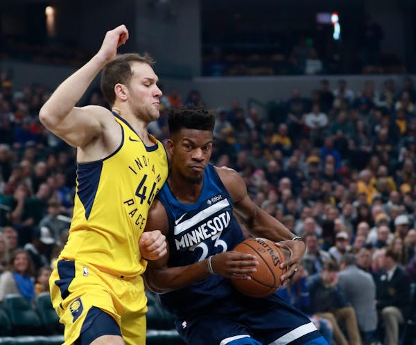 Minnesota Timberwolves guard Jimmy Butler, right, drives with the basketball defended by Indiana Pacers forward Bojan Bogdanovic in the first half of 