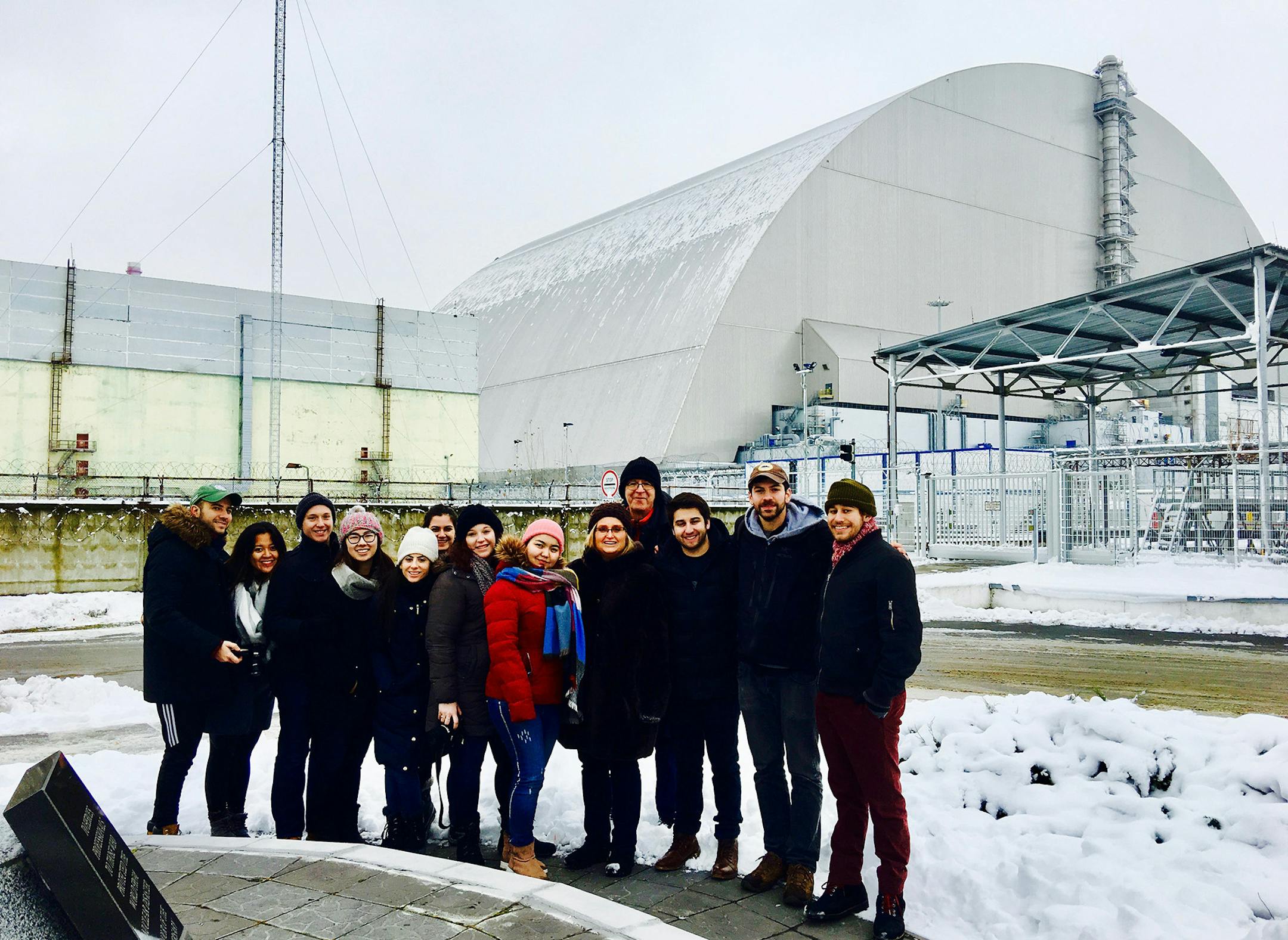 Standing in front of the new containment shield covering the remains of the exploded reactor are the writer, her husband and 11 students from Syracuse University. From left, Peter Levchuck, Weng Cheong, Zach Lang, Madelyn Urabe, Gilat Melamed, Raven Rentas, Taylor Lang, Malika Budur, writer Cheryl Reed, her husband Greg Stricharchuk (a former business editor at the Chicago Tribune), Dan Prager, Zach Krahmer and Elijah Shama. (Cheryl L. Reed/Chicago Tribune/TNS)