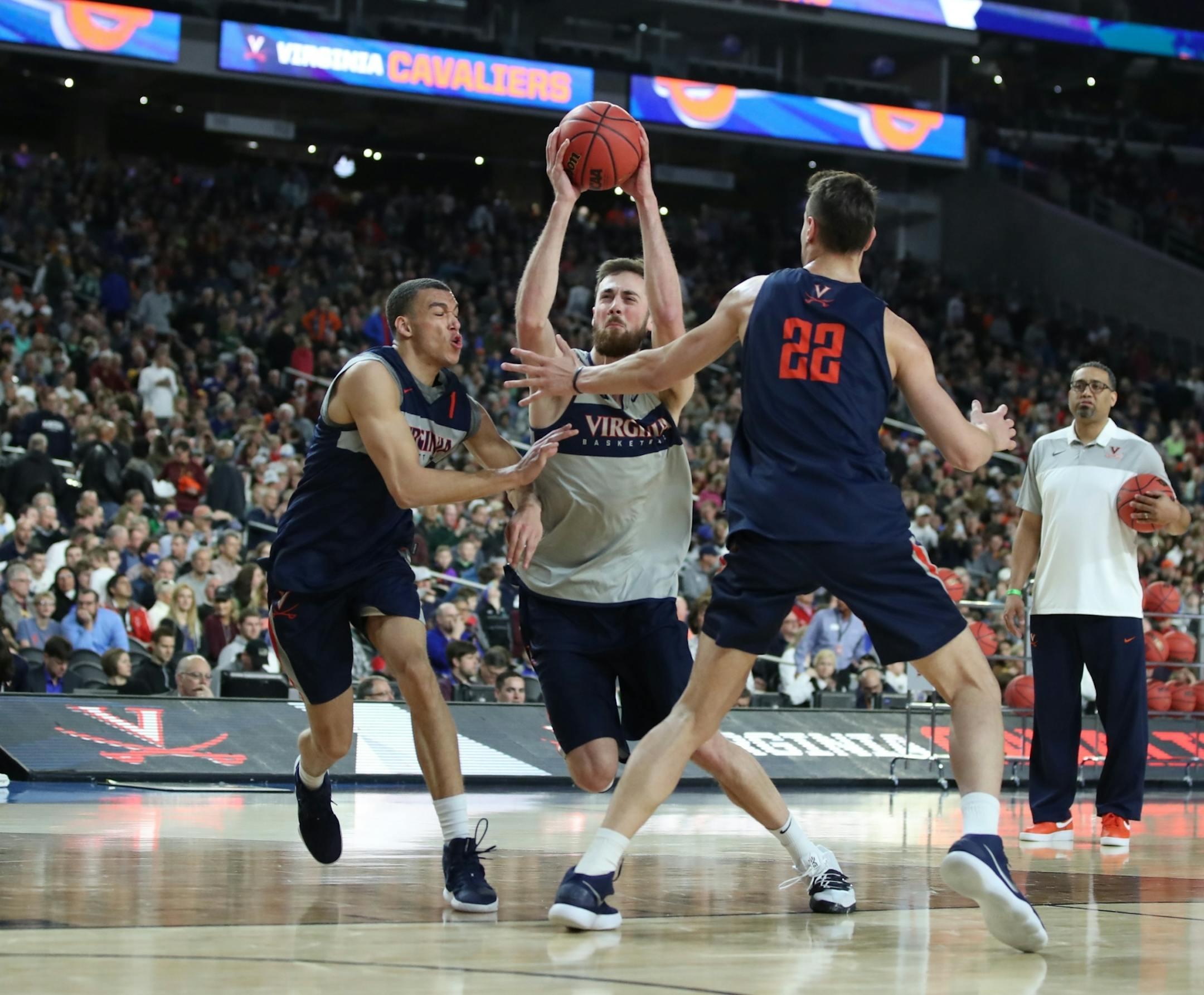 Virginia Cavaliers forward Jay Huff (30) drove between Virginia Cavaliers forward Francesco Badocchi (1) and Virginia Cavaliers center Francisco Caffaro (22) during open practice.