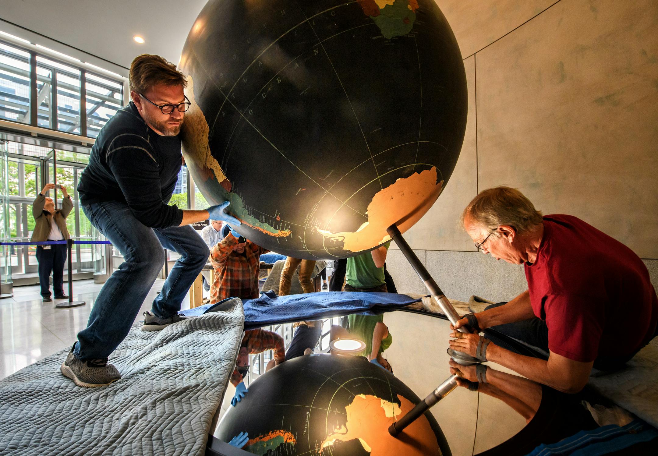 Tim Quady and Hal Eckhart from Blue Rhino Studio in Eagan guided the globe into position.