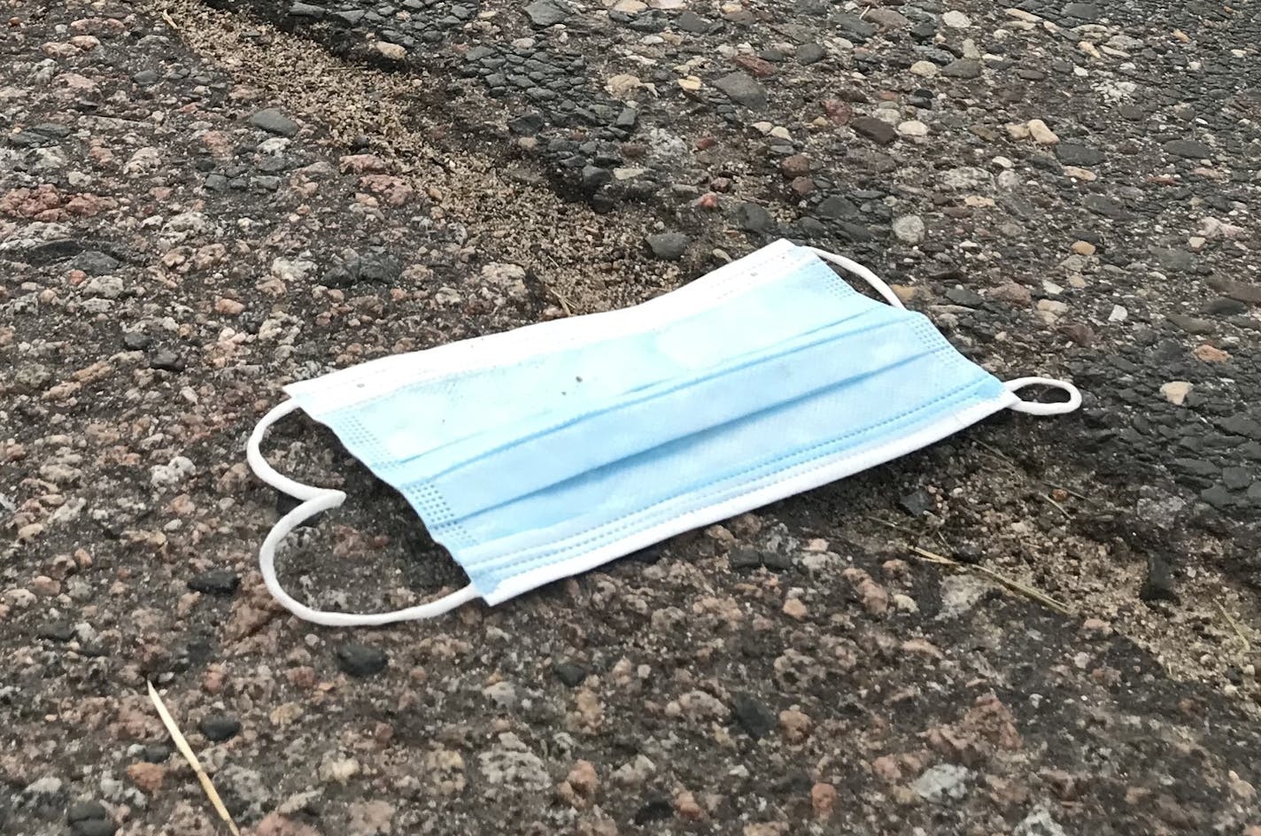 A protective face mask as roadside litter.