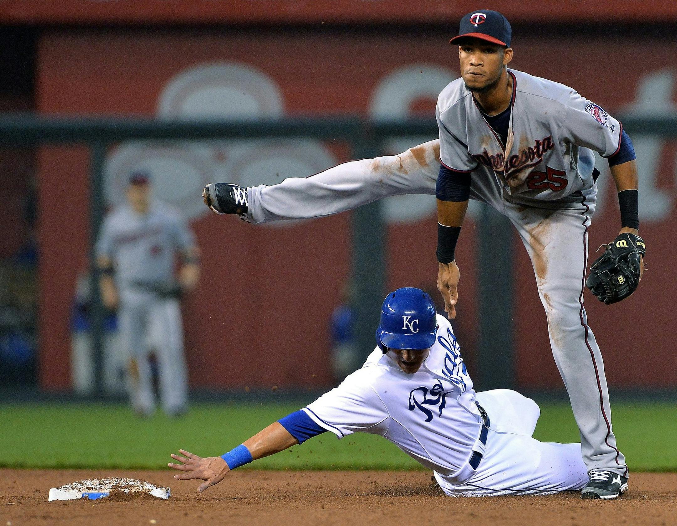 Twins shortstop Pedro Florimon watches his throw to first to compete the double play on Kansas City Royals' Chris Getz after forcing out David Lough at second
