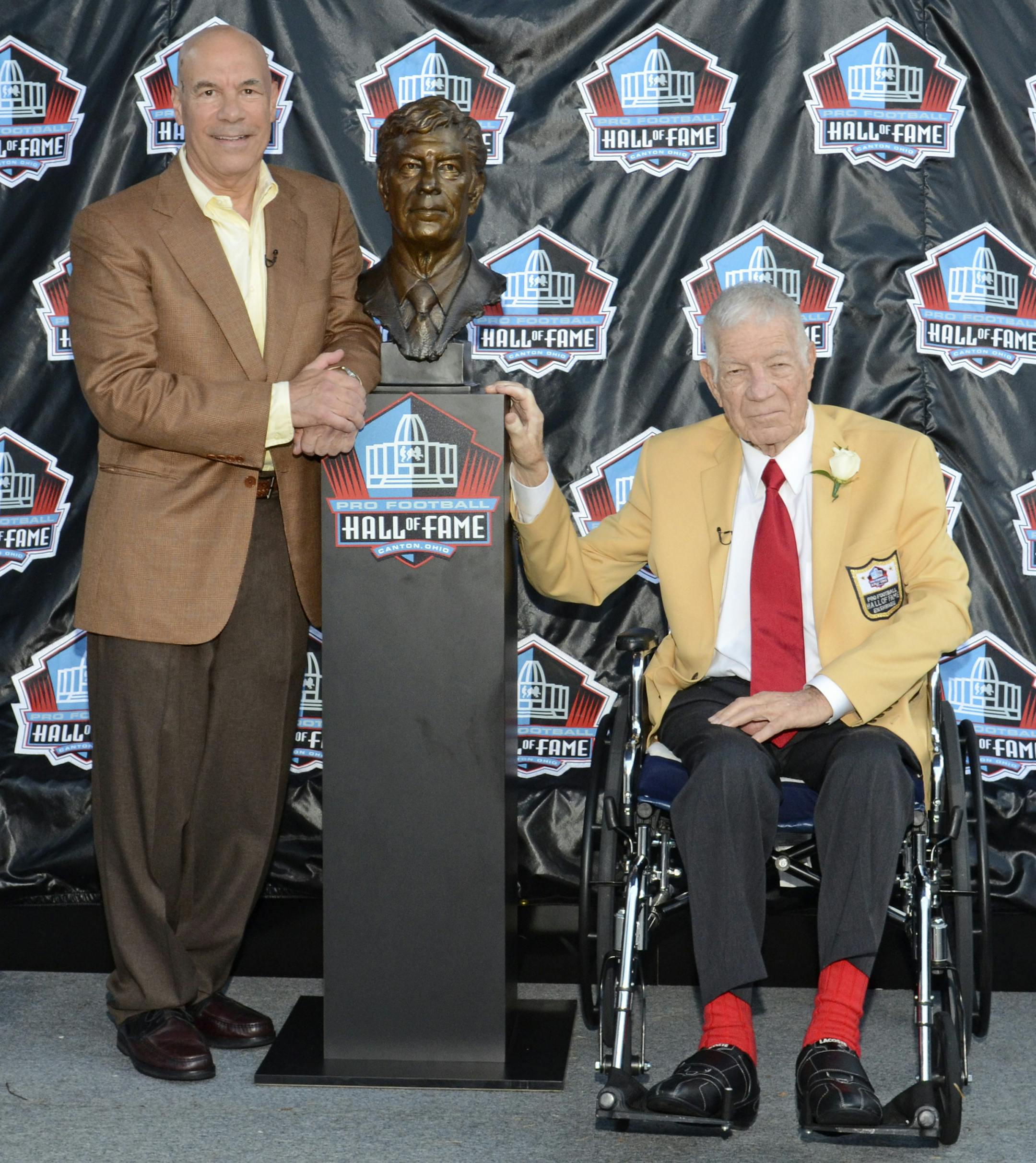 FILE - In this Aug. 6, 2011 photo provided by the Pro Football Hall of Fame, Ed Sabol, right, poses with a bust of himself and his presenter Steve Sabol during induction ceremonies at the Pro Football Hall of Fame, in Canton, Ohio. NFL Films President Steve Sabol has died from brain cancer. He was 69. The NFL said Sabol died Tuesday, Sept. 18, 2012, 18 months after he was diagnosed with a tumor on the left side of his brain. Sabol started working with his father Ed, NFL Films' founder, in 1964,