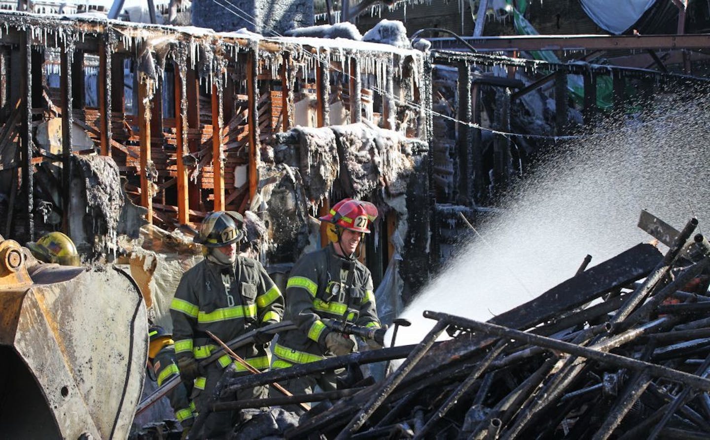 Minneapolis firemen from engine company 27 continued to put water on hot spots Friday afternoon 1/25/13, after a fire destroyed the building that housed Beeks Pizza and Diamond Lake Rental, in South Minneapolis on 1/24/13.